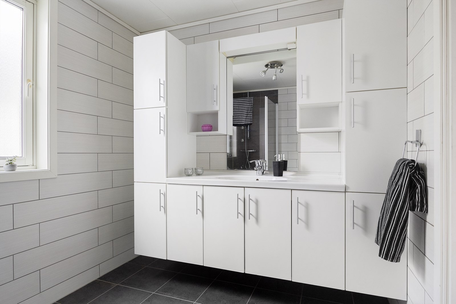 Et lekkert og funksjonelt bad med fliser på både gulv og vegger. Gulvvarmen gjør badet behagelig å bruke året rundt. Galleribilde