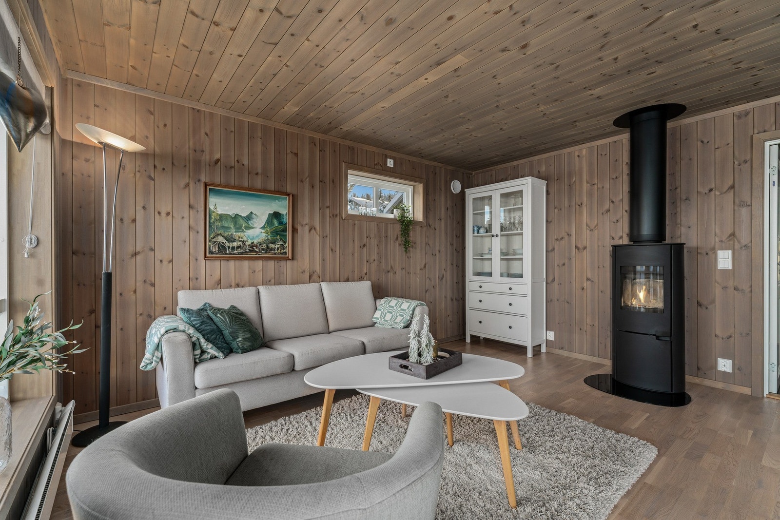 Hytta har en åpen og sosial stue- og kjøkkenløsning med parkett på gulv og trepanel på vegger og i tak - som skaper en lun og ekte hyttefølelse. Galleribilde