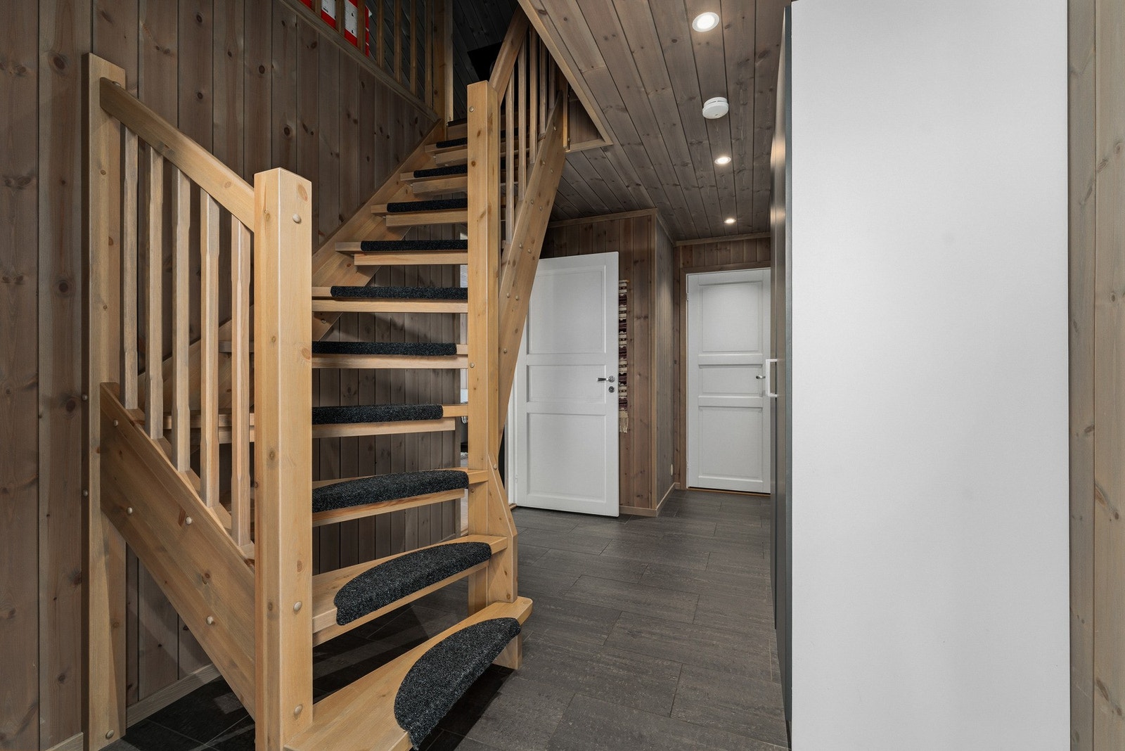 Entreen er romslig og funksjonell, med flislagt gulv og elektriske varmekabler som sørger for behagelig varme på kalde dager. Her er det god plass til yttertøy og sko, samt et stort garderobeskap som gir rikelig med oppbevaringsmuligheter. Galleribilde