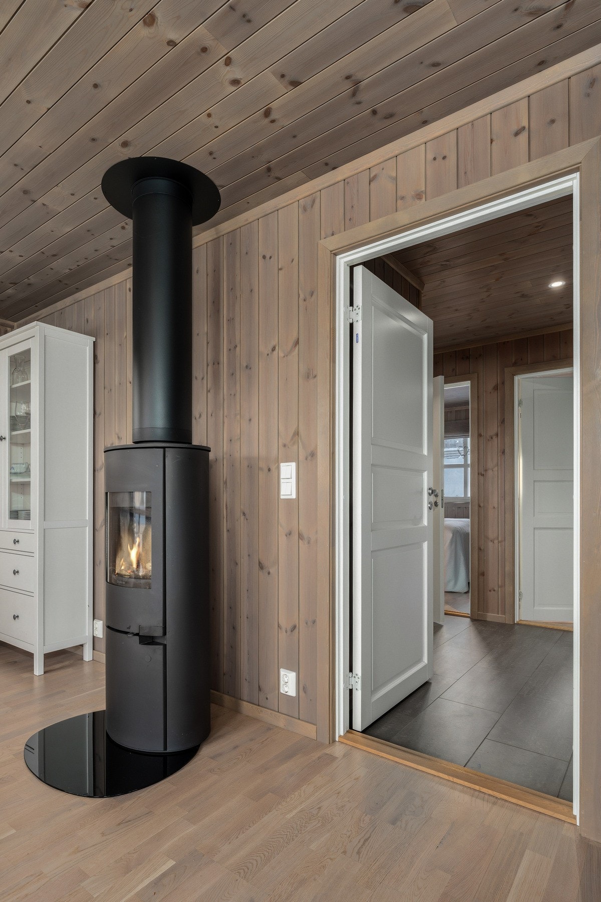 Den effektive peisen gir både god varme og ekstra stemning på kjølige høst- og vinterkvelder. Det er satt inn dør mellom gang og stue, noe som er svært praktisk - særlig når man ønsker å skjerme soverommene fra oppholdsrommet. Galleribilde