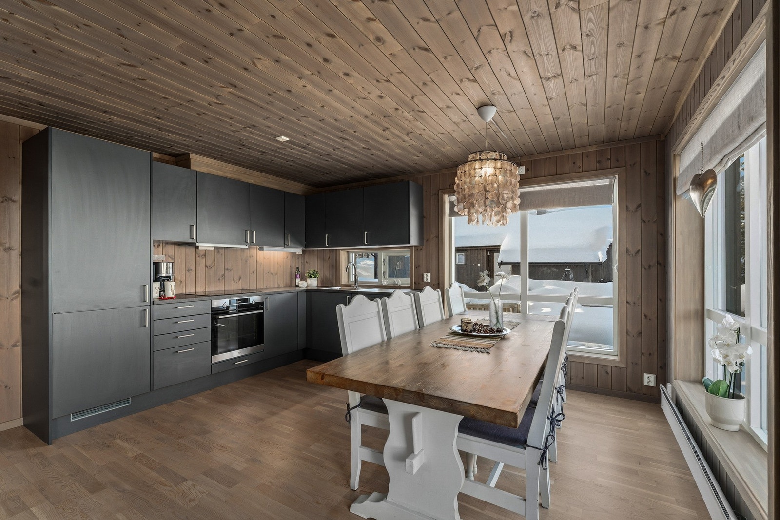 Kjøkkenet fremstår som praktisk og stilrent, med innredning med glatte fronter og laminat benkeplate. Galleribilde