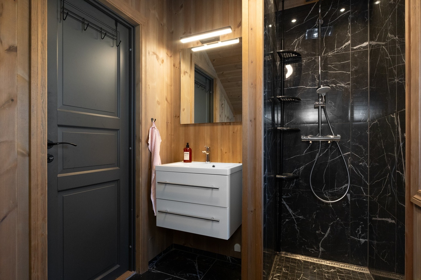 Et godt utnyttet rom med dusjnisje, innredning med nedfelt servant i skuffer samt vegghengt toalett Galleribilde