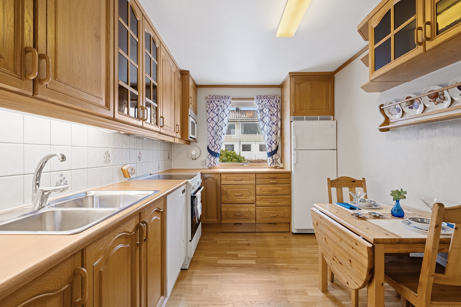 Tidløst kjøkken med plass til et mindre frokostbord. Galleribilde