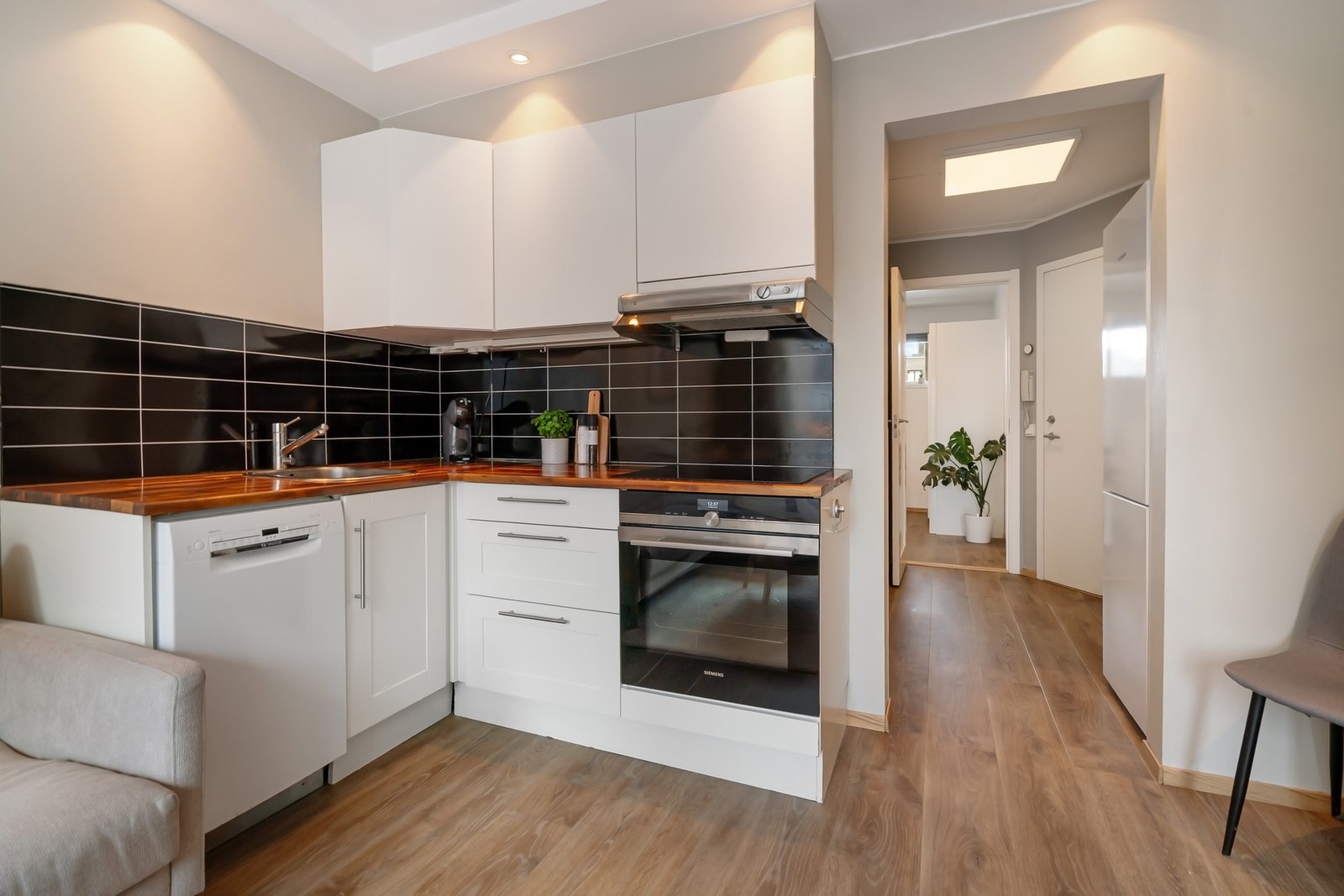 Kjøkkeninnredning med malte profilerte fronter. Heltre benkeplate med nedsenket oppvaskkum og platetopp. Galleribilde