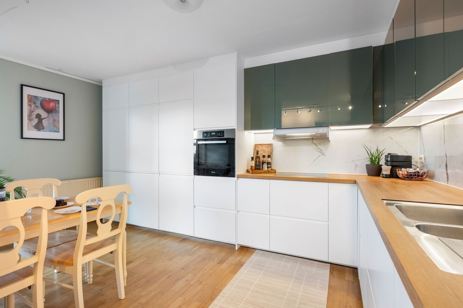 Kjøkkenet har Ikea-innredning med slette fronter og heltre benkeplate. Galleribilde