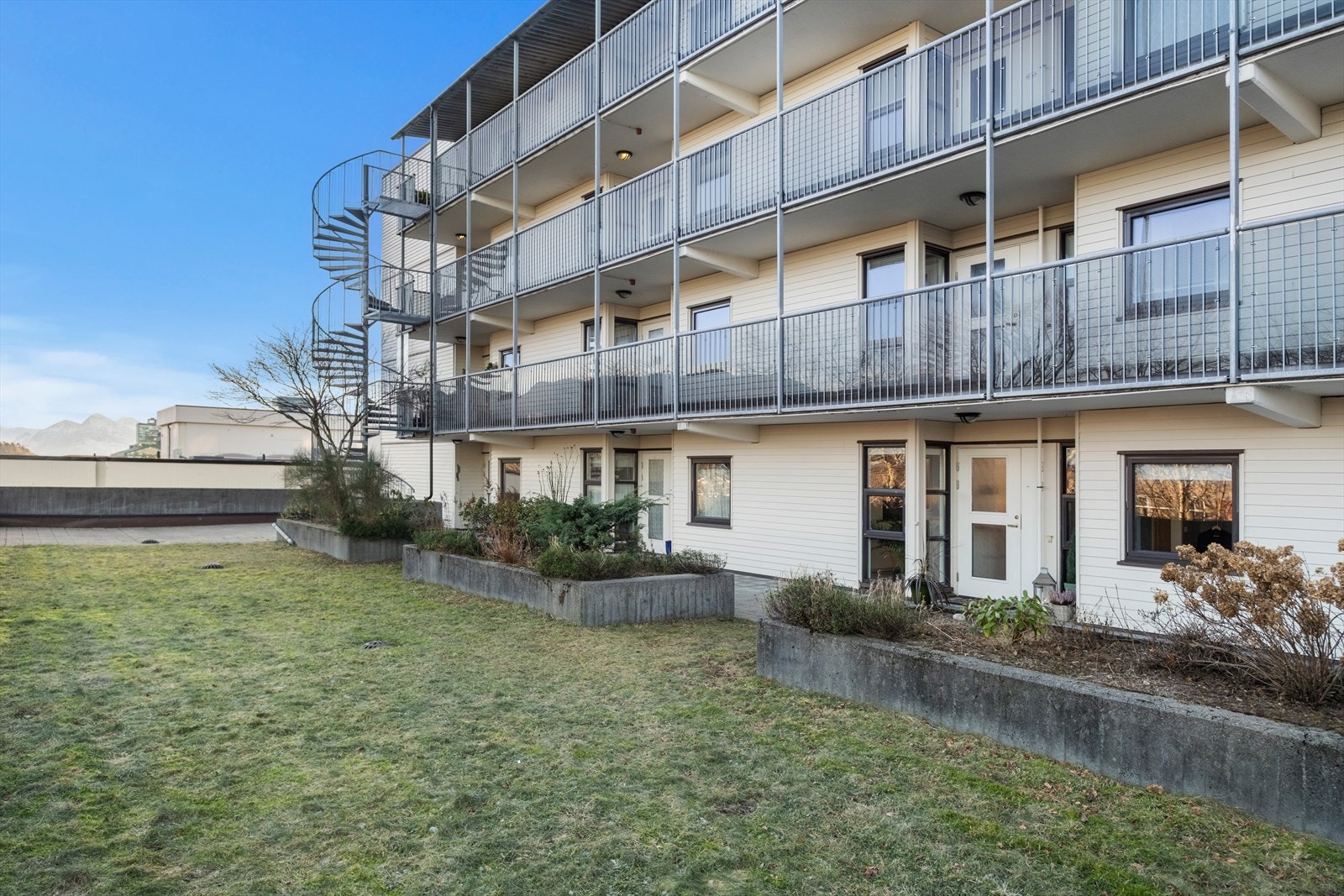 Bygget har en fasade av teglstein og bordkledning, og det er balkonger med rekkverk i metall. Galleribilde