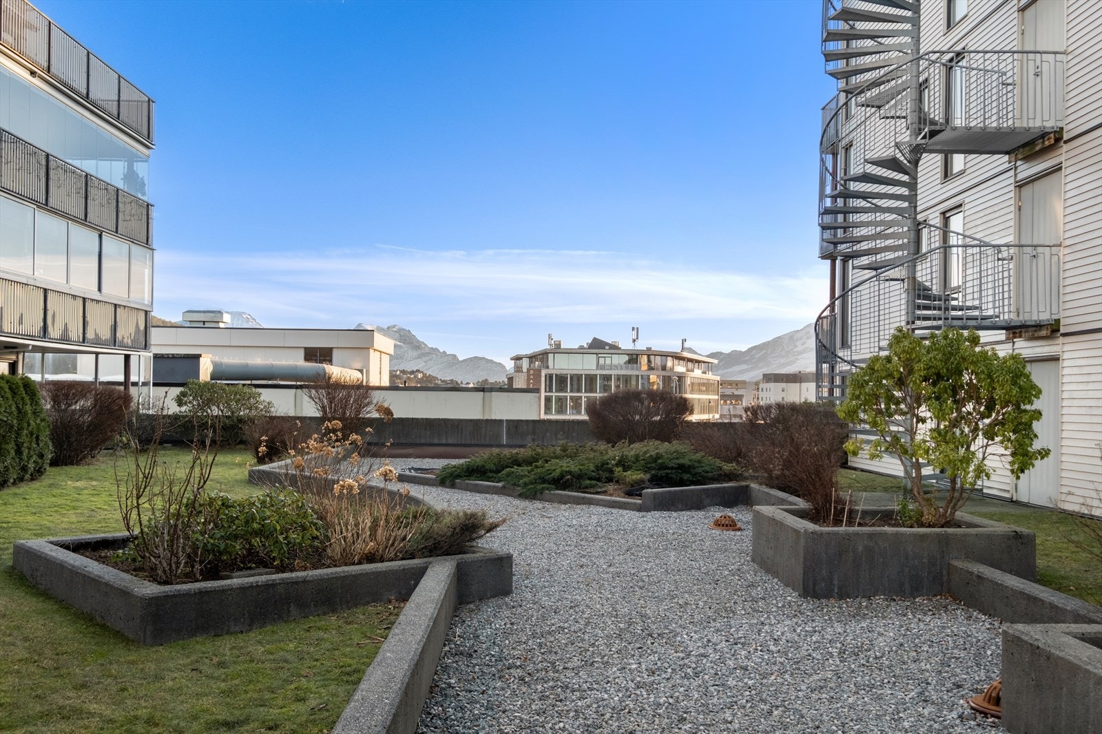 Gruslagte gangstier og beplantede bed gir et pent uteområde. Galleribilde