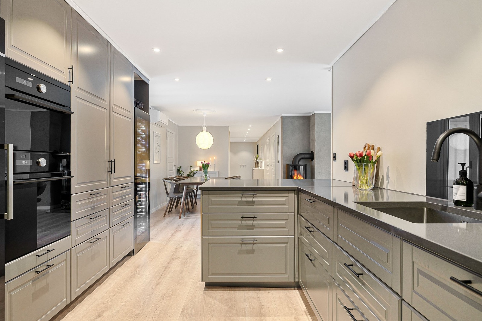 Kjøkkenet har profilerte fronter i en delikat gråfarge og med mørke benkeplater og detaljer gir det et stilig og moderne uttrykk. Galleribilde