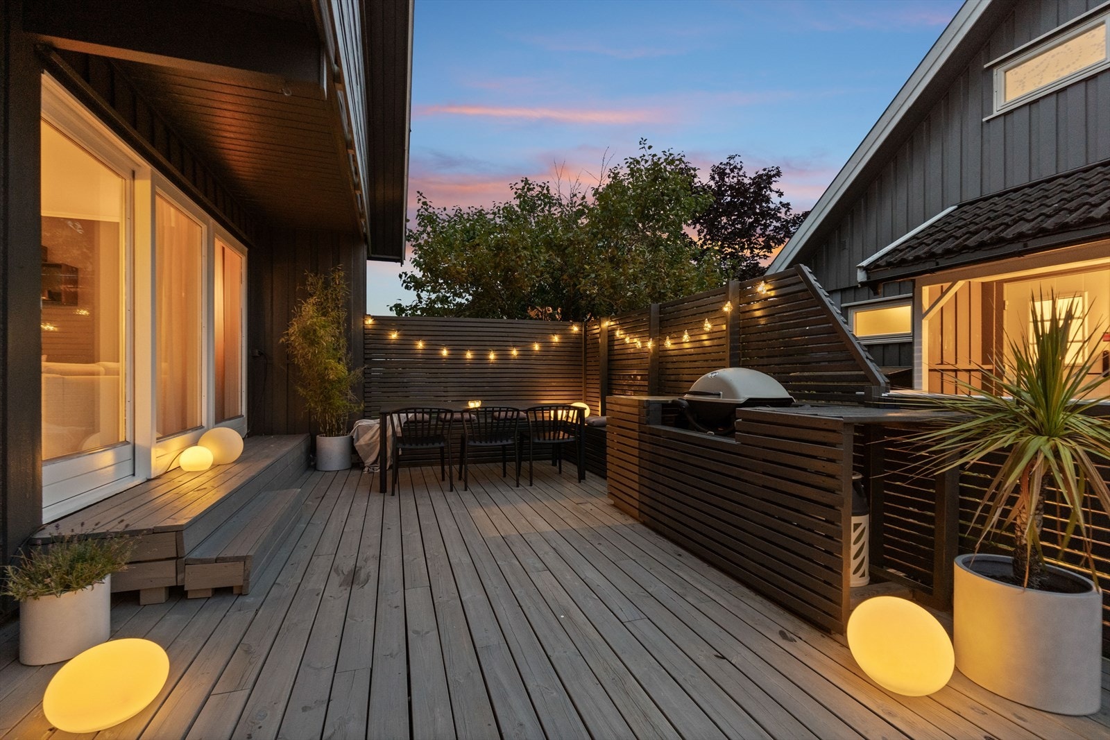 Lunt og koselig uteområde med levegger som skjermer for vind, og en hyggelig grillplass som inviterer til lange, varme sommerkvelder. Galleribilde