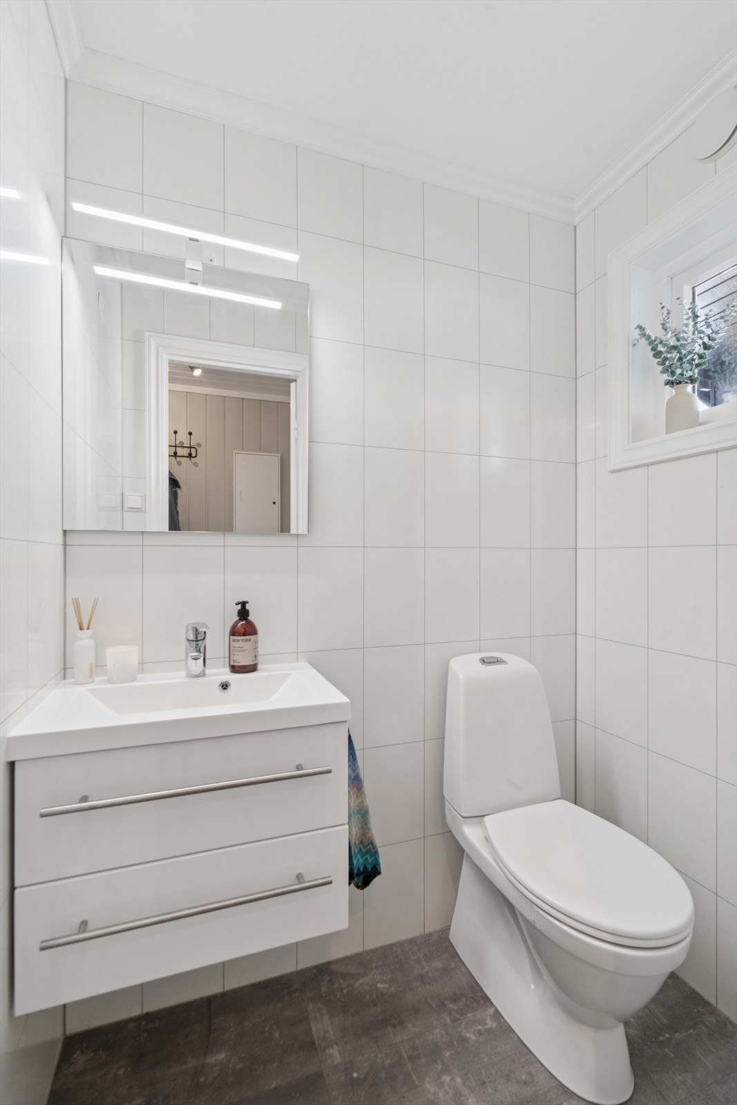 I første etasje ligger et separat toalettrom som ble oppusset i 2020. Rommet har laminat på gulvet, våtromsplater på veggene og malt himling, og er innredet med både toalett og servant. Galleribilde