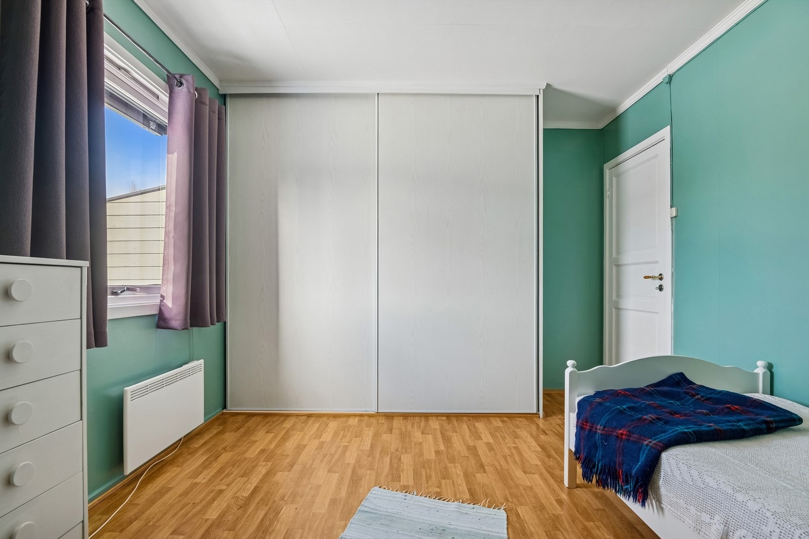 Et av soverommene er utstyrt med en stor skyvedørsgarderobe for effektiv oppbevaring. Galleribilde