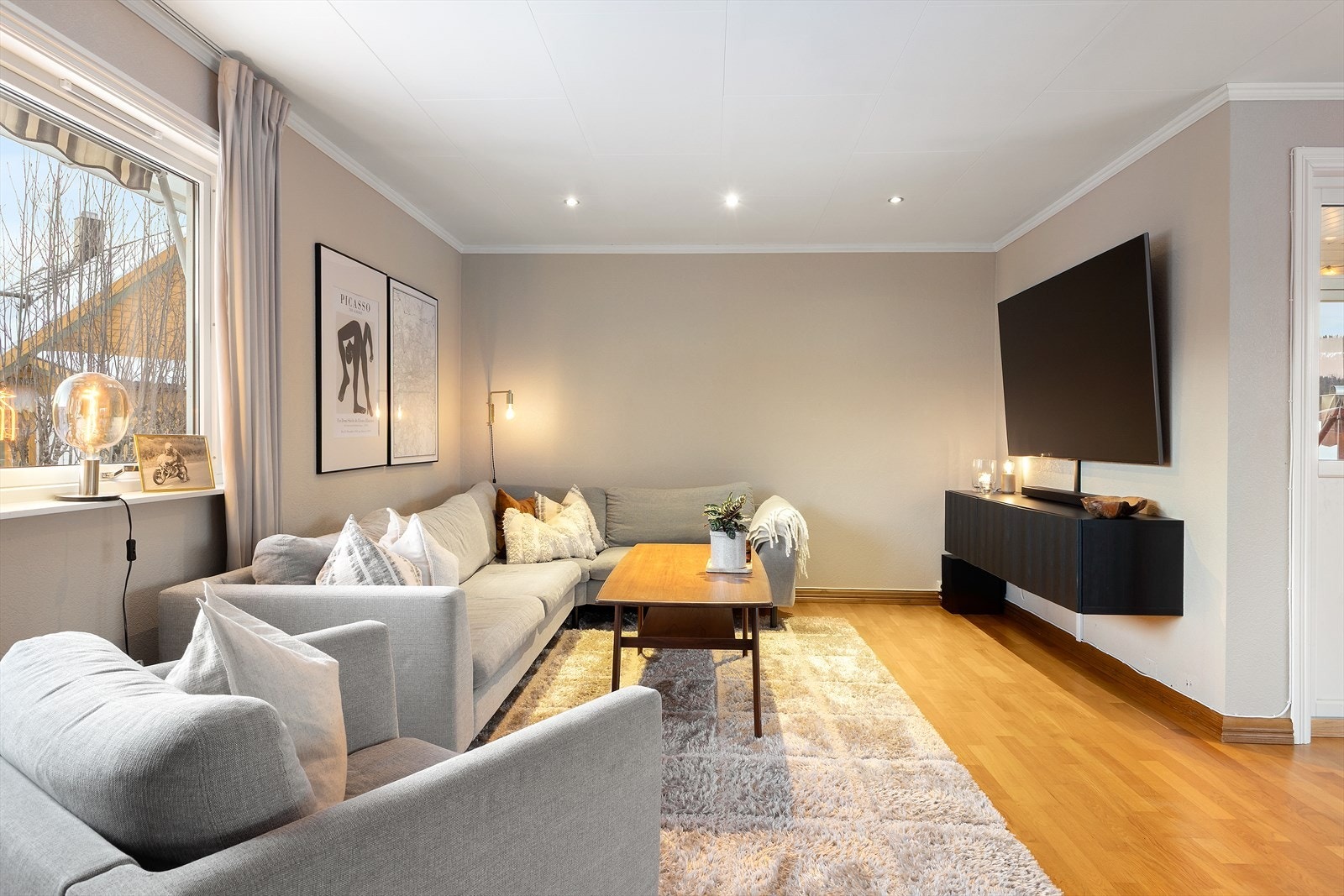 Boligen har en romslig stue med spotter i himling og utgang til veranda. Galleribilde