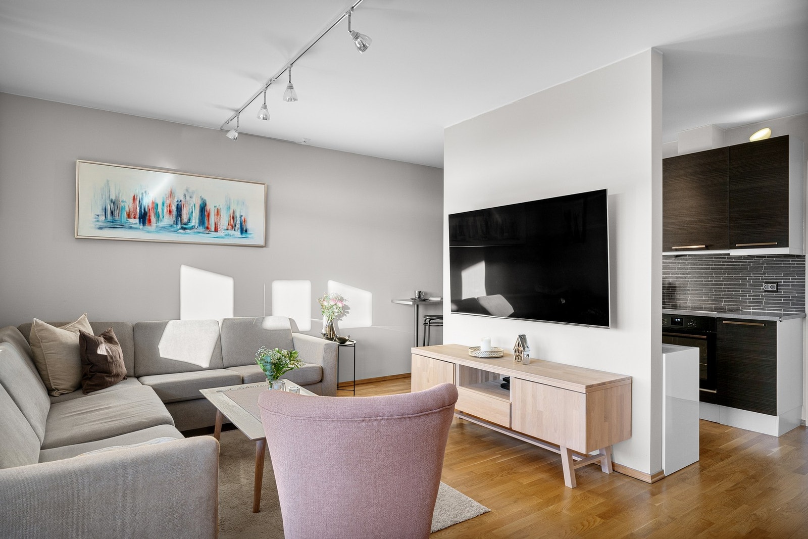 Stuen har delvis åpen forbindelse med kjøkkenet - perfekt for både hverdagsliv og gjester Galleribilde