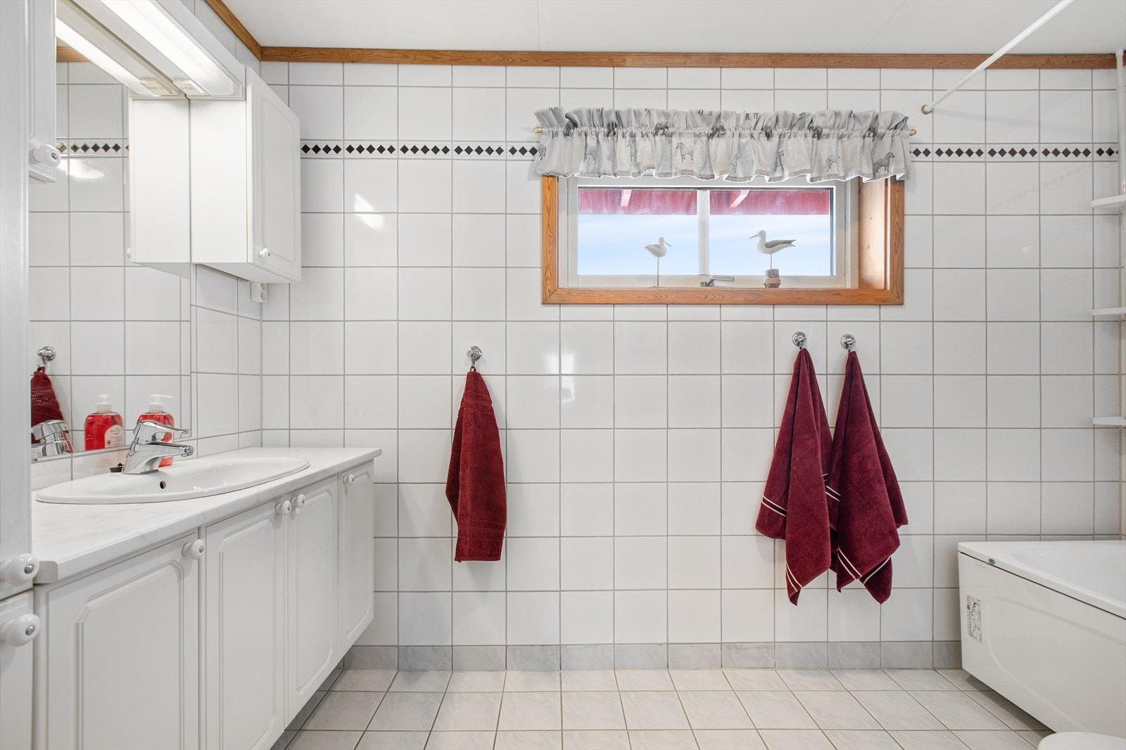 Badet har flislagte vegger og gulv med varme som gir et funksjonelt bad. Galleribilde