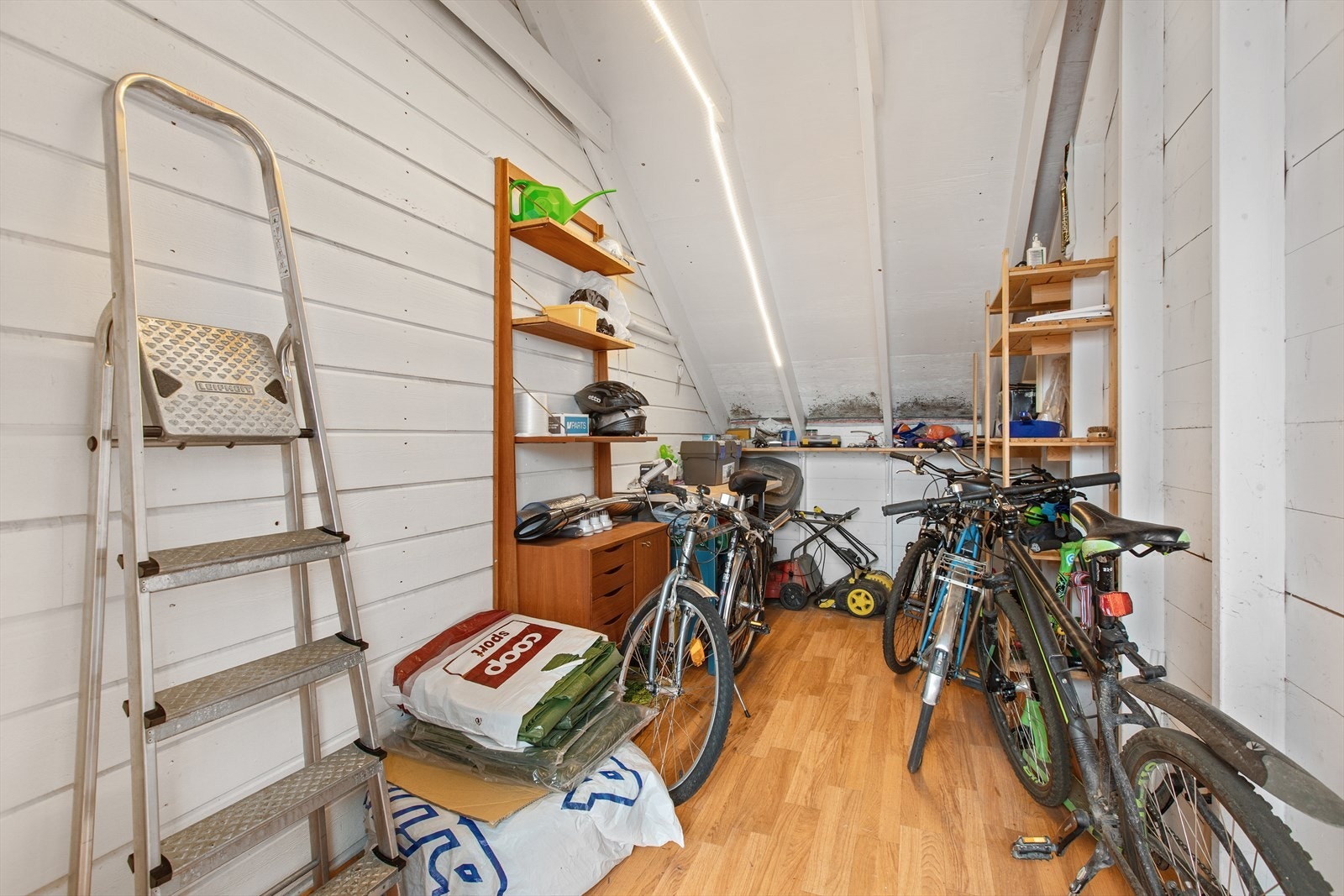 Boden på siden av garasjen har tregulv og gode lagringsmuligheter, i tillegg er det isolert og oppvarmet bod ved inngangsdøren. Galleribilde