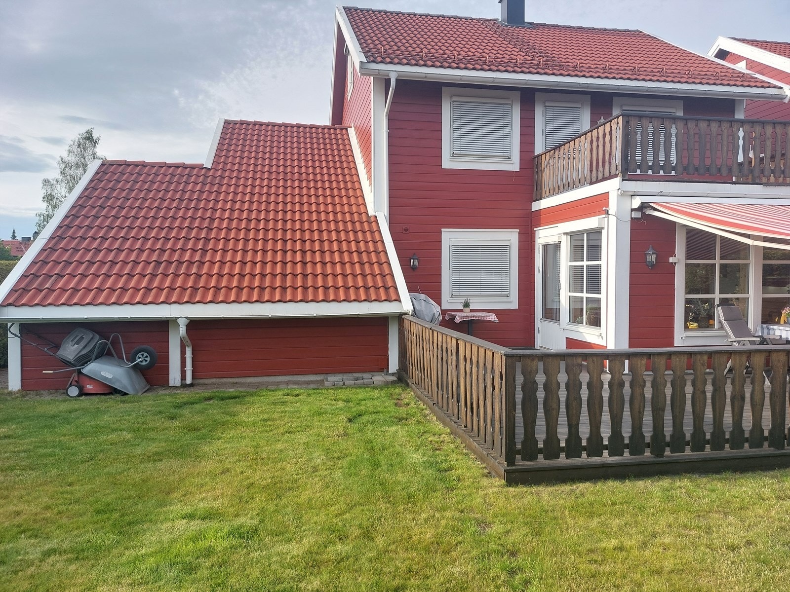 Eiendommen inkluderer en terrasse med treverk, som gir et fint uteområde tilknyttet hagen. Sommerbilde er tatt av selger. Galleribilde