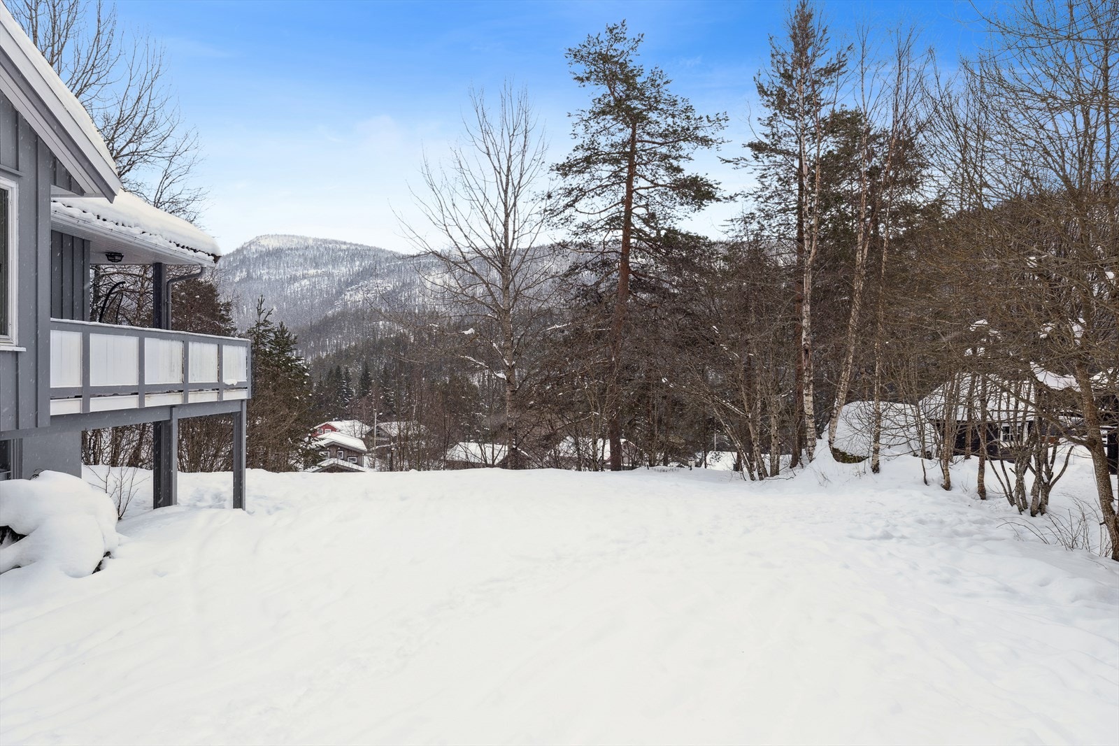 Romslig hage med gode solforhold og flott utsyn mot omkringliggende natur. Et flott uteområde for både lek og avslapning. Galleribilde