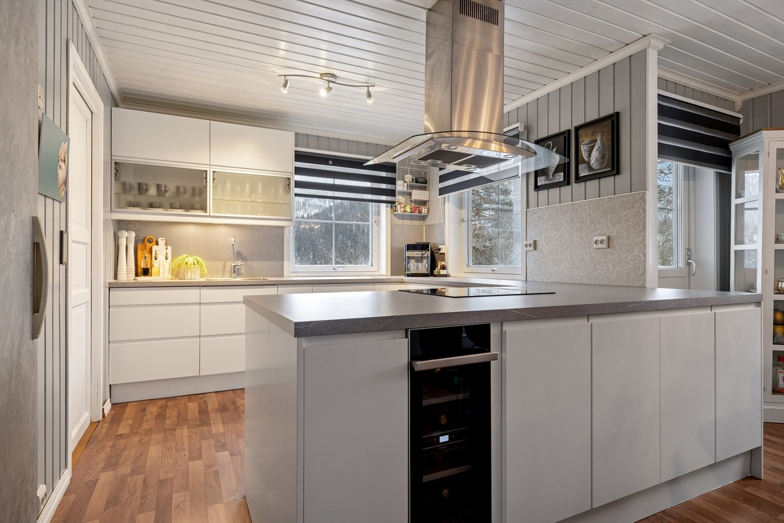 Pent og funksjonelt kjøkken med rikelig benke- og skapplass, integrerte hvitevarer og praktisk kjølerom. Galleribilde