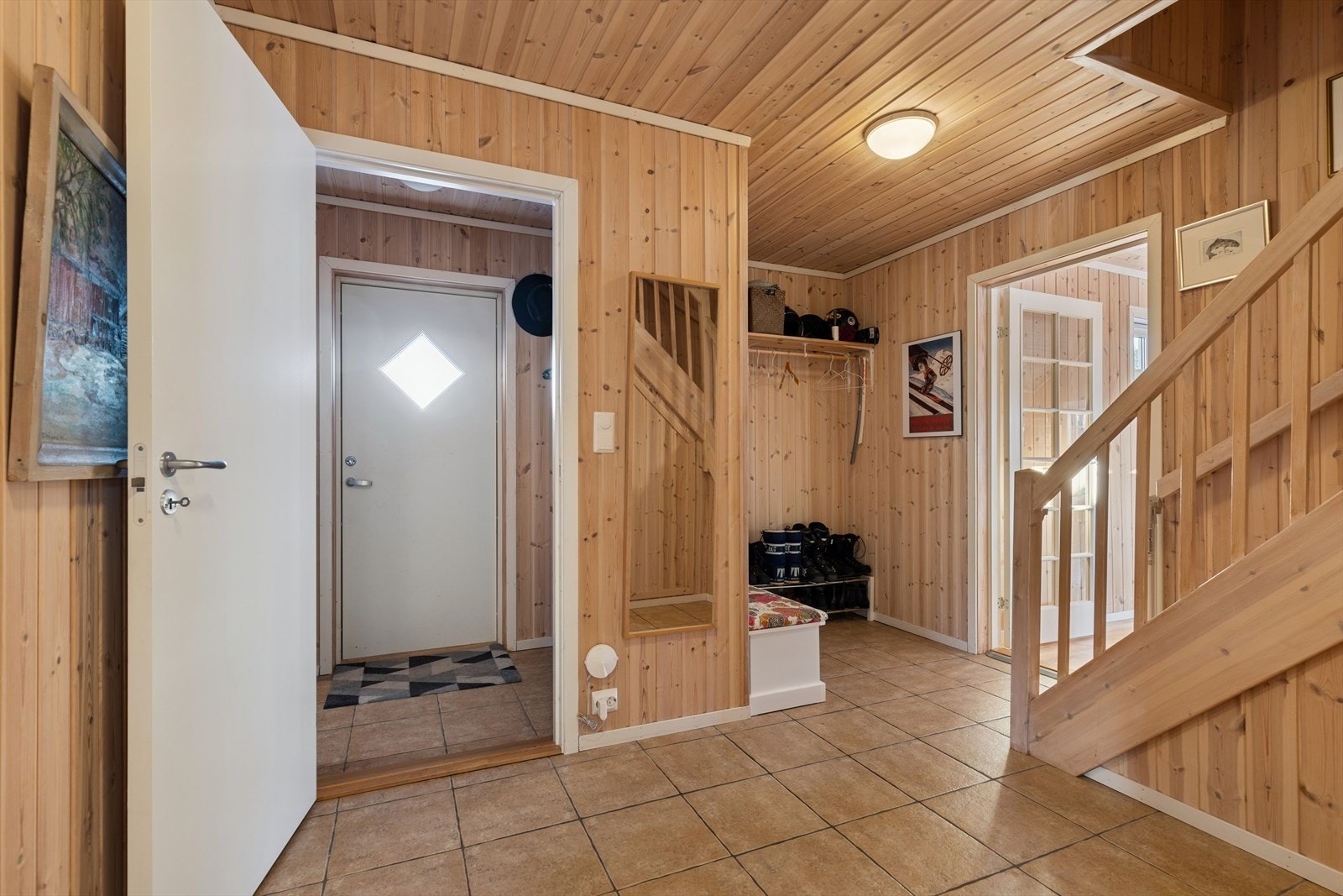 Velkommen inn! I entréen blir du møtt av praktisk vindfang med tilhørende bod for oppbevaring, samt en romslig gang til av og påkledning. Galleribilde