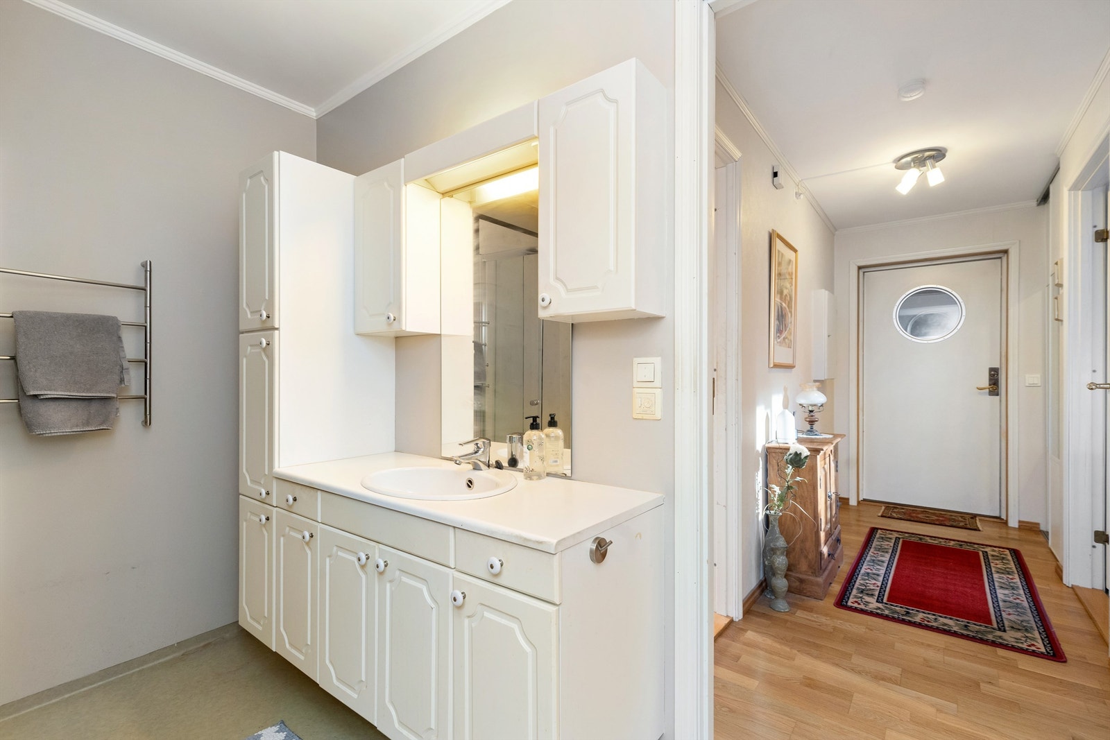 Lyst og praktisk bad med klassisk, hvit baderomsinnredning og gode oppbevaringsmuligheter. Rommet fremstår velholdt og funksjonelt. Galleribilde