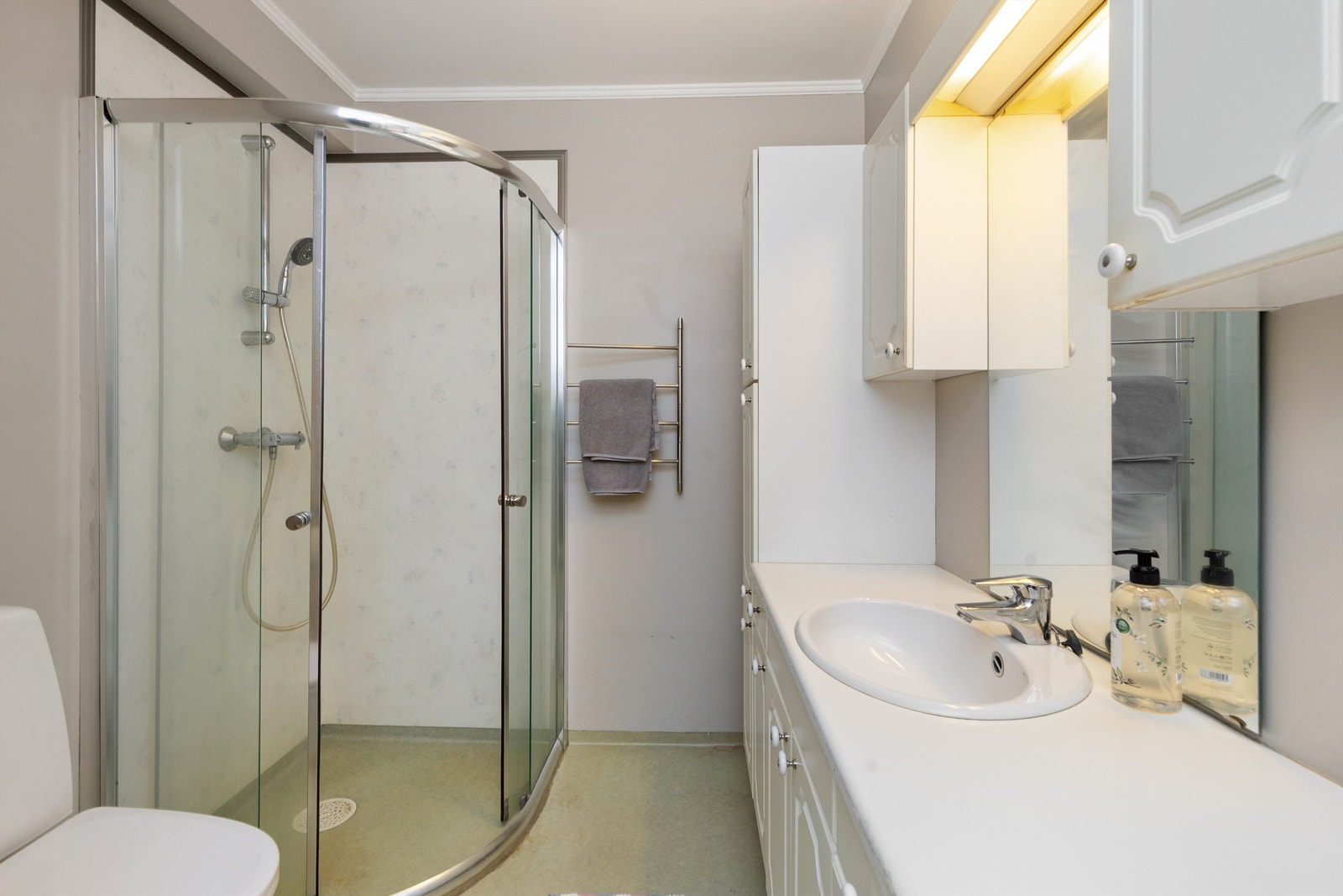 Romslig servant med god benkeplass og integrert oppbevaring i både under- og overskap. Galleribilde