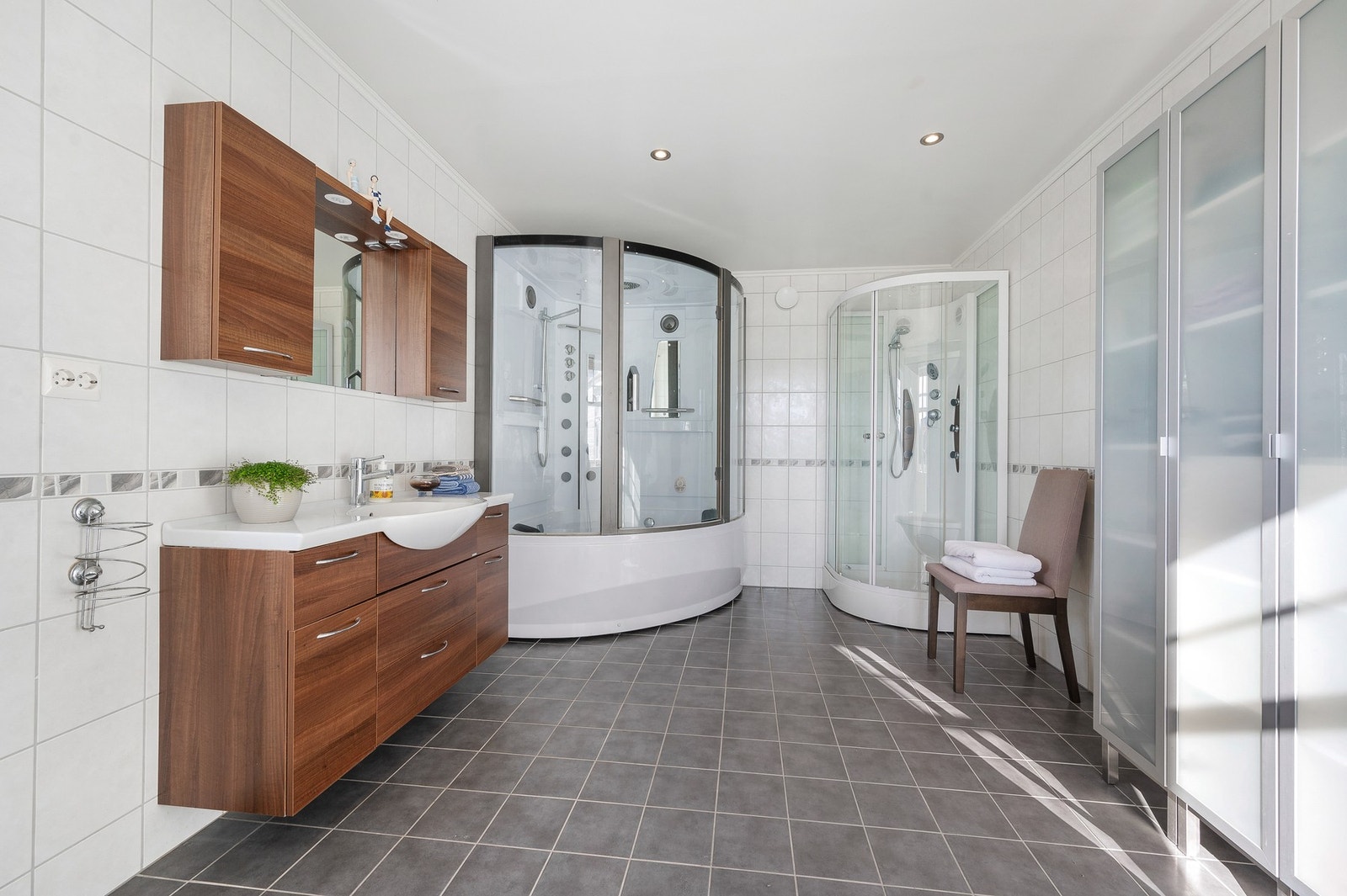 Særdeles romslig bad i tilbygget (2011/12). Flislagte vegger og gulv med varmekabler. To dusjkabinett og god innredningsplass. Galleribilde