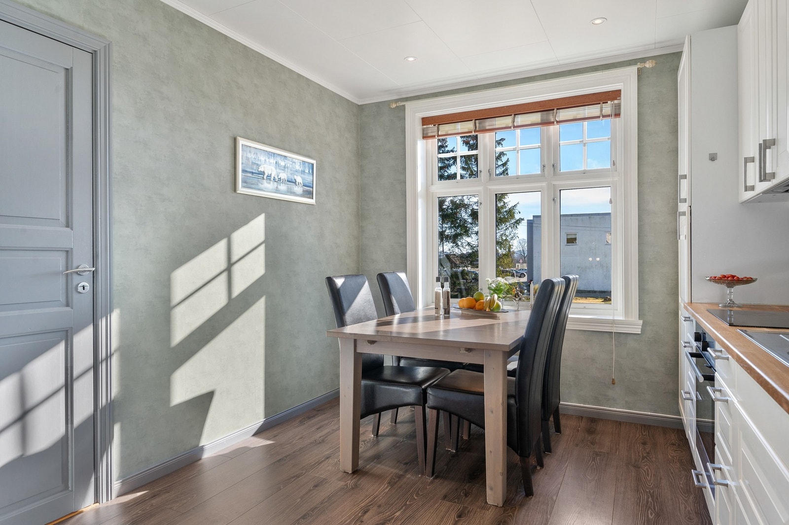 Lun spiseplass ved vindu. Et trivelig kjøkken som inviterer til både hverdag og besøk. Galleribilde