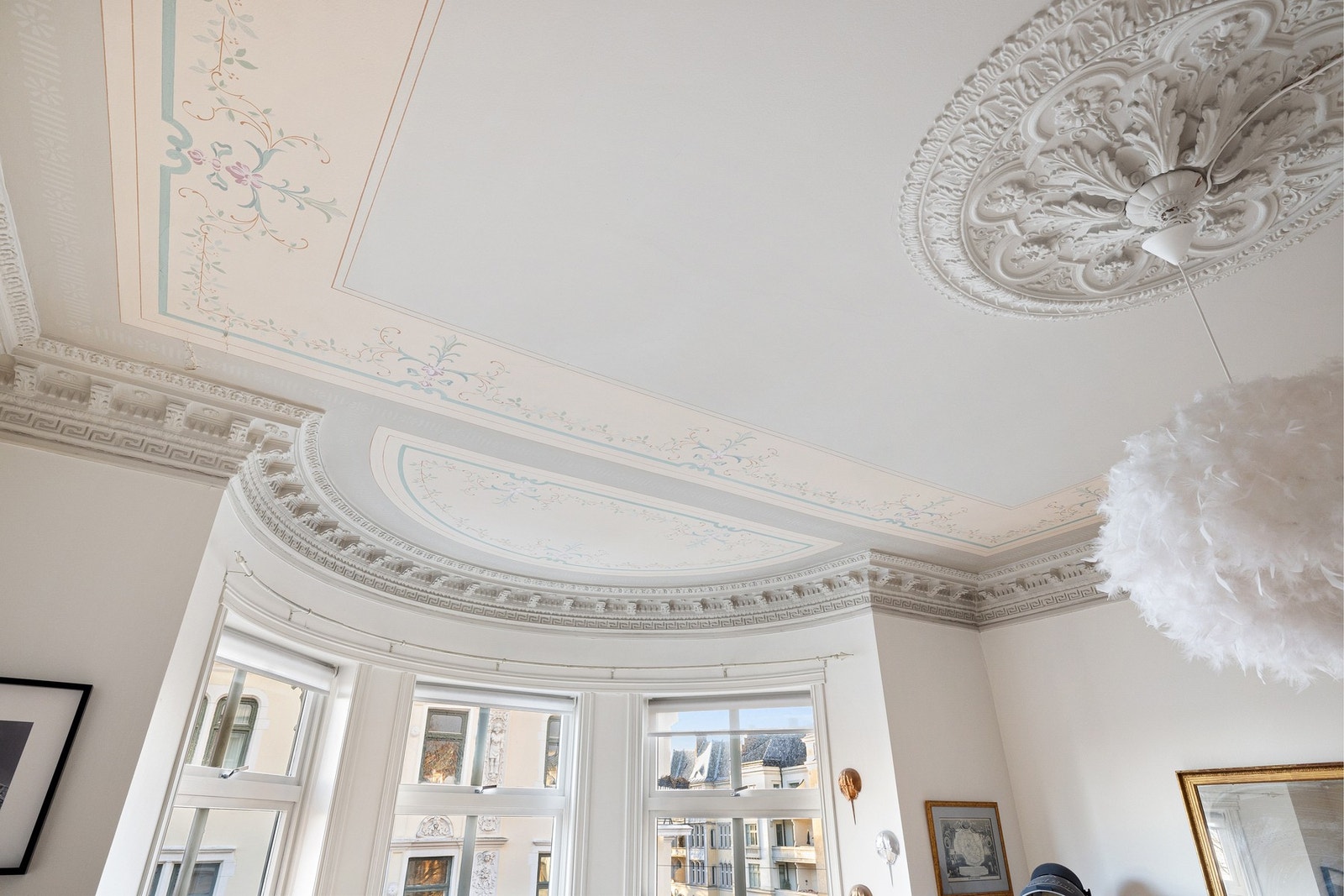 Detaljer som stukkatur og rosetter gir boligen karakter og forankrer den i byggets historiske uttrykk. Galleribilde