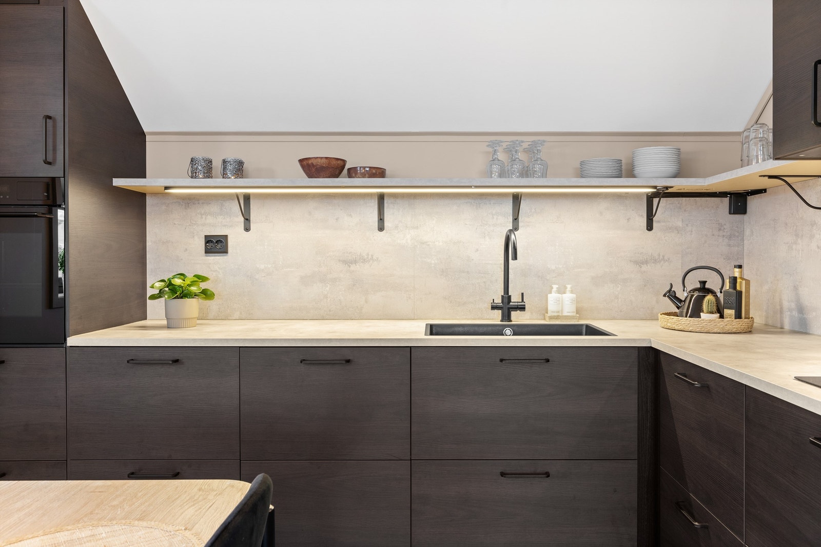 Detaljer som belysning under hyllene og automatisk vannstopper understreker funksjonaliteten. Galleribilde