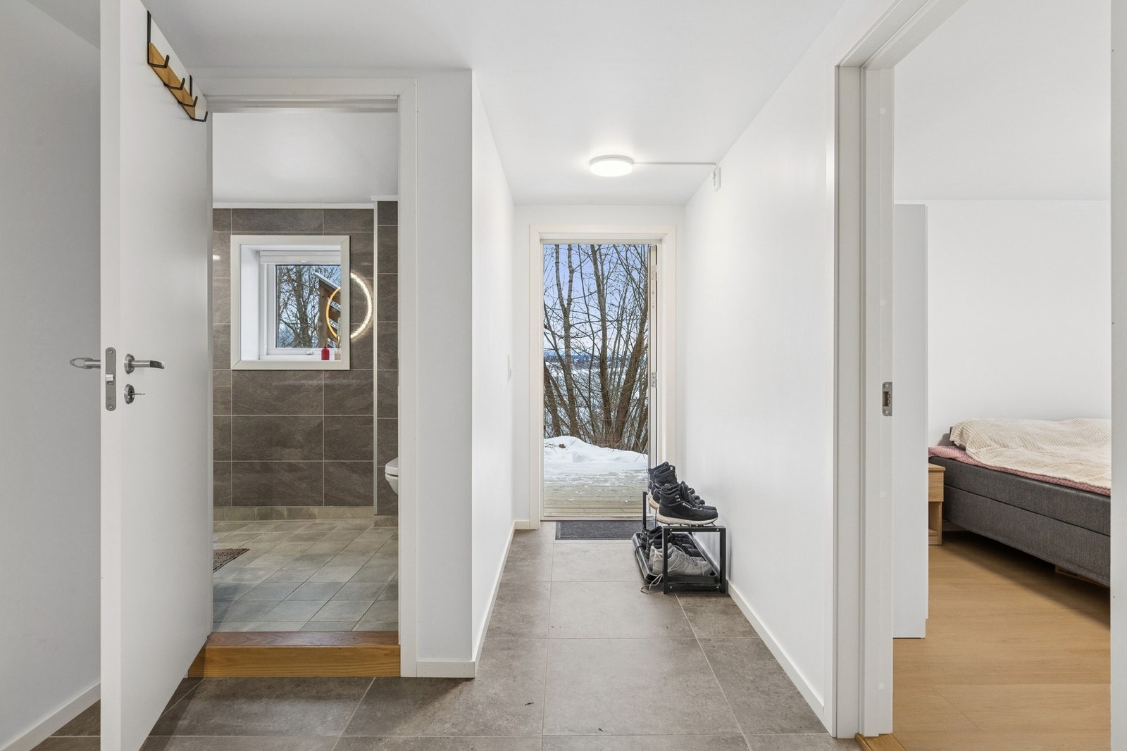 Lys og innbydende entré med flislagt gulv som er praktisk i hverdagen, samt god plass til oppheng av yttertøy og sko. Galleribilde