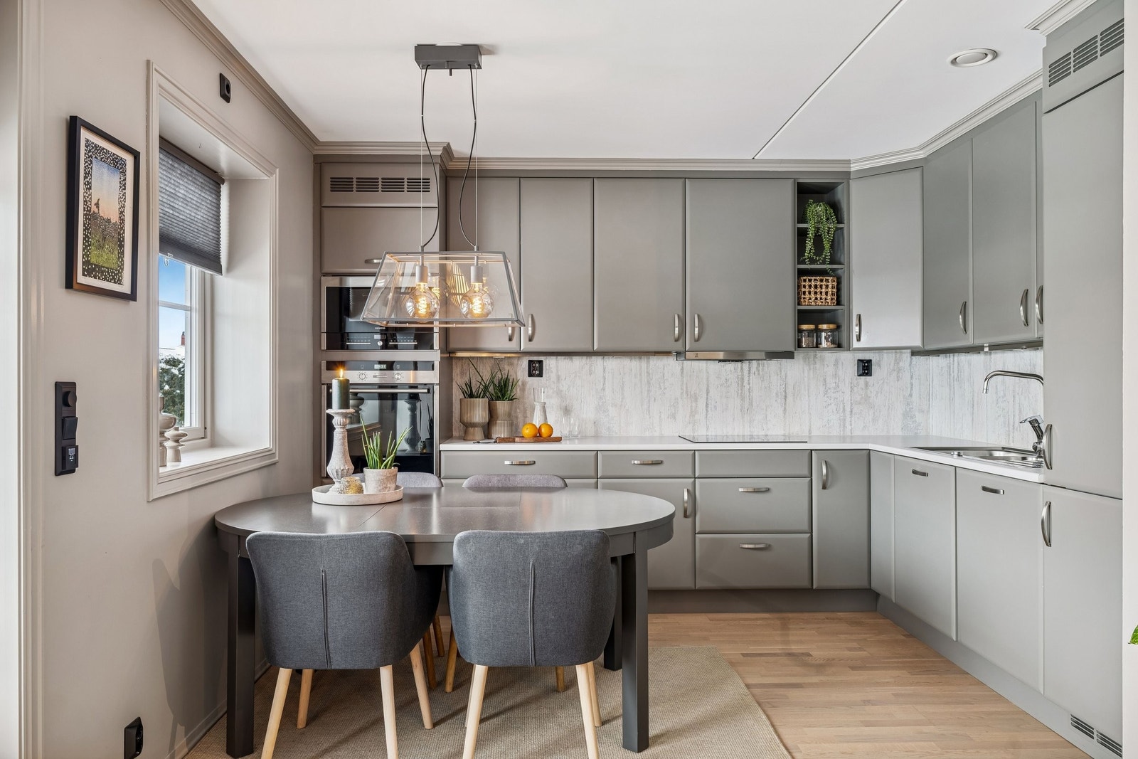 Stilrent Huseby-kjøkken med glatte fronter og integrerte hvitevarer. Godt utstyrt med mikroovn, stekeovn, platetopp, oppvaskmaskin og kjøleskap med frysedel. Laminat benkeplate. Galleribilde