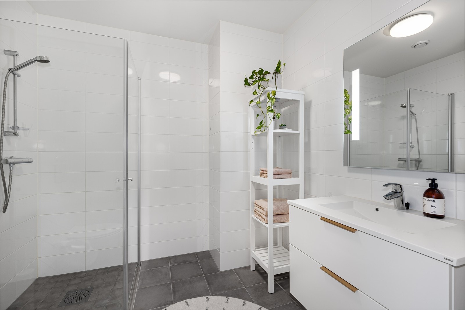 Delikat og moderne bad med flislagte overflater. Praktisk servantløsning med skuffer som gir god plass til oppbevaring. Galleribilde