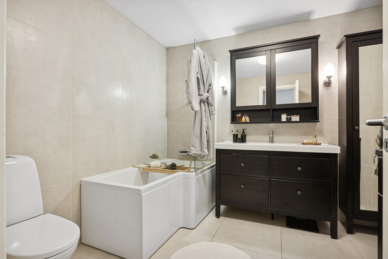 Bad i sokkel er moderne med gulvvarme, badekar, romslig baderomsinnredning og opplegg for vaskemaskin med arbeidsbenk. Galleribilde