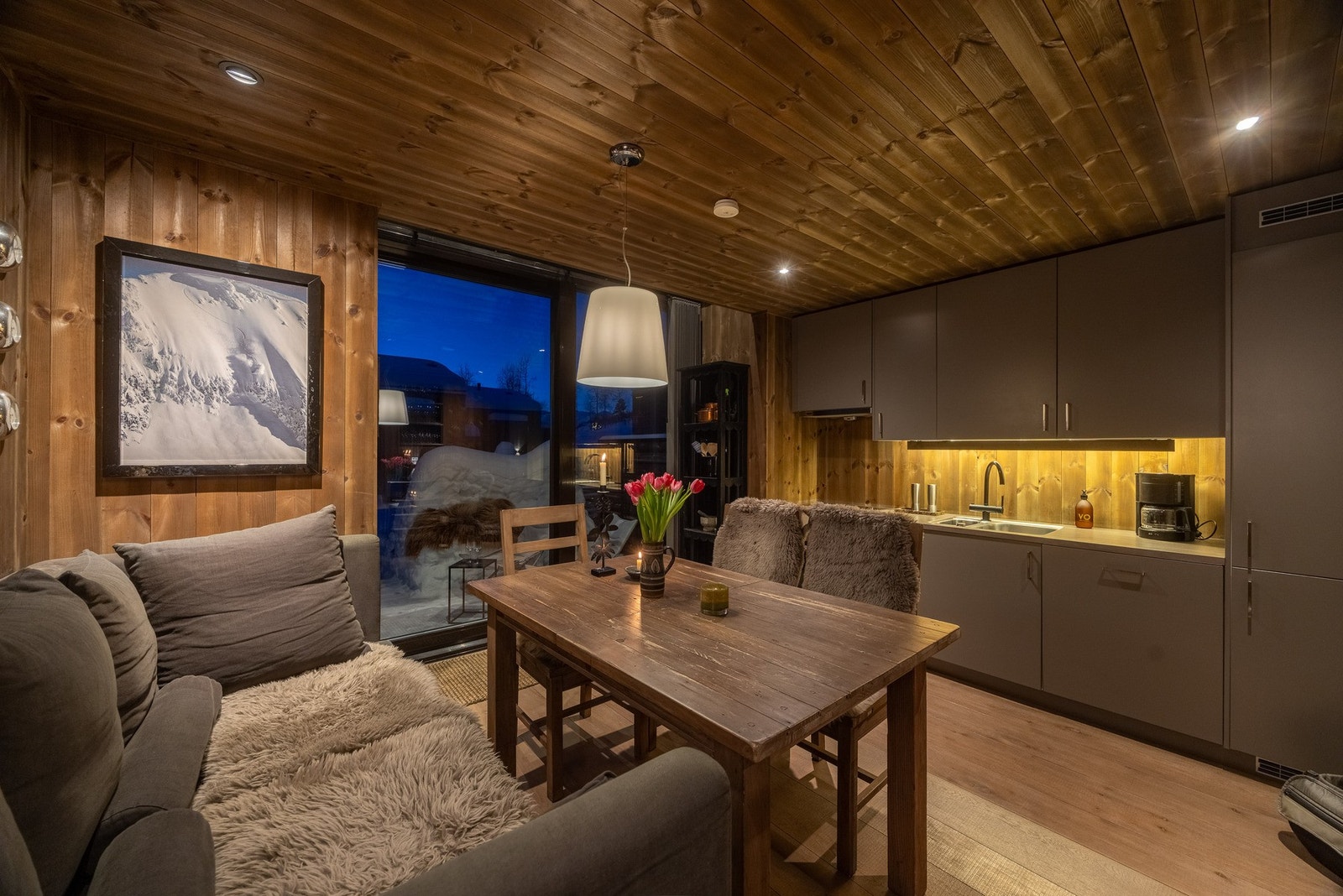 Hytta går over fire halvplan og har to oppholdssoner. Her fra kjøkken og spisestue. Galleribilde