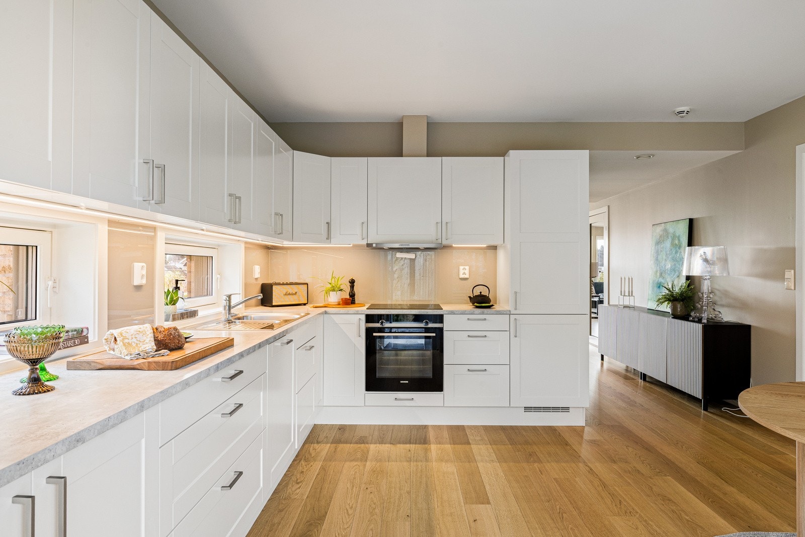 Lyst og tilbaketrukket kjøkken med plass til spisegruppe Galleribilde