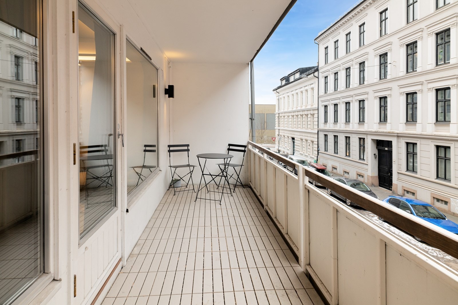 Adkomst fra stuen til en 9 m2 nordvestvendt balkong med betongdekke og plastfliser på gulv. Galleribilde