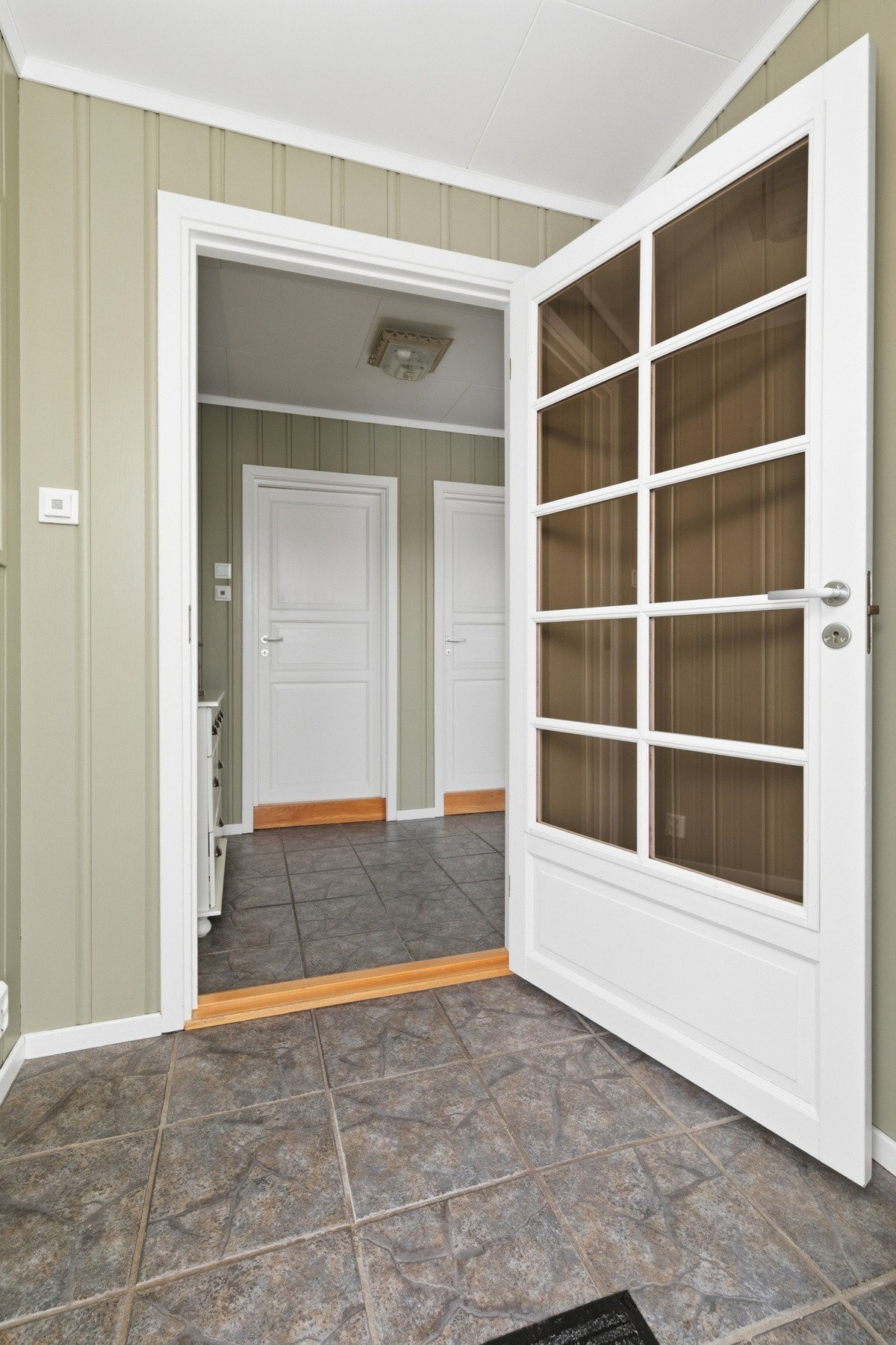 Her blir man ønsket velkommen i en flislagt entré. Galleribilde