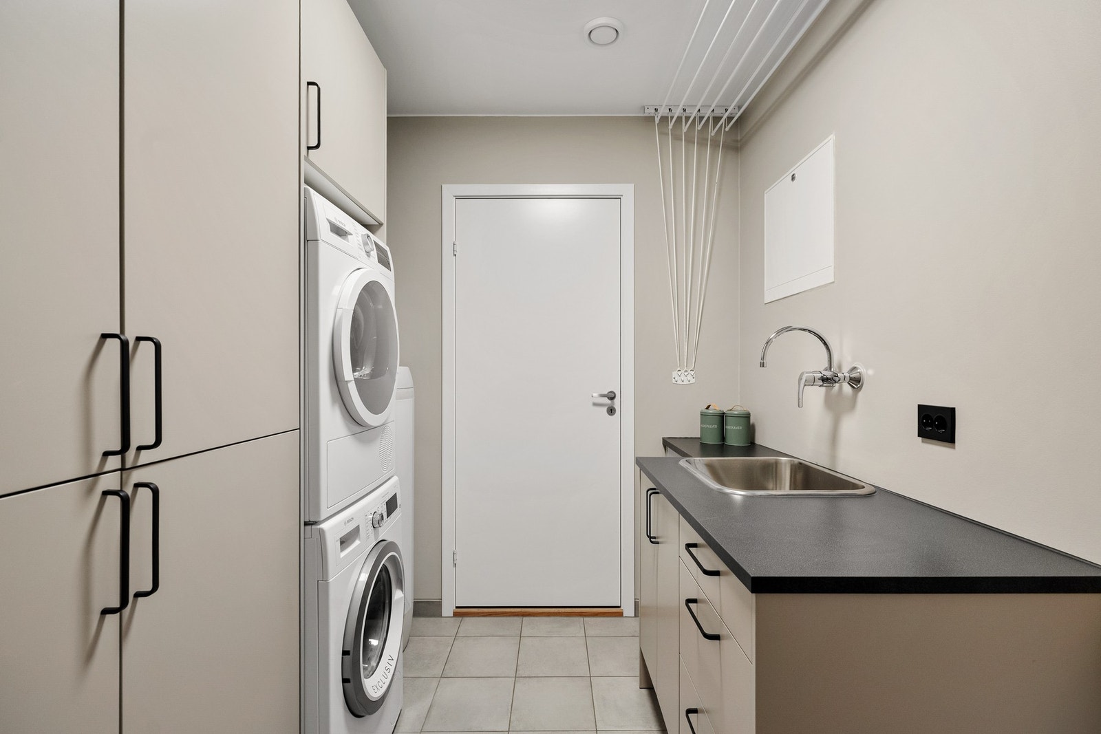 Lyst og funksjonelt vaskerom med innredning med vask og garderobeløsning Galleribilde