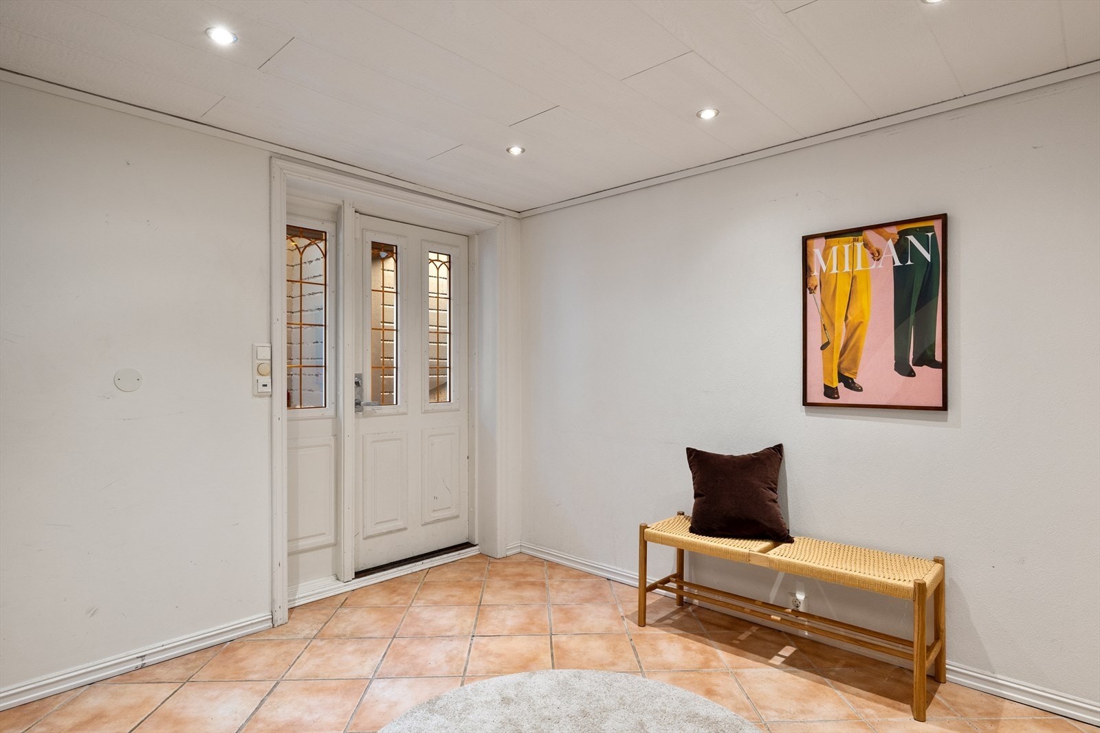 Flislagt gang i underetasjen med spotter i himling. Galleribilde