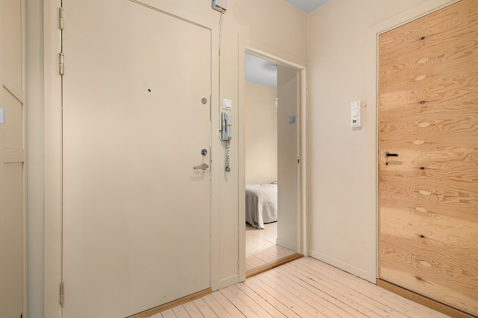 Montert porttelefon på vegg ved inngangsdøren og sikringsskap med automatsikringer i felles trapperom. Galleribilde