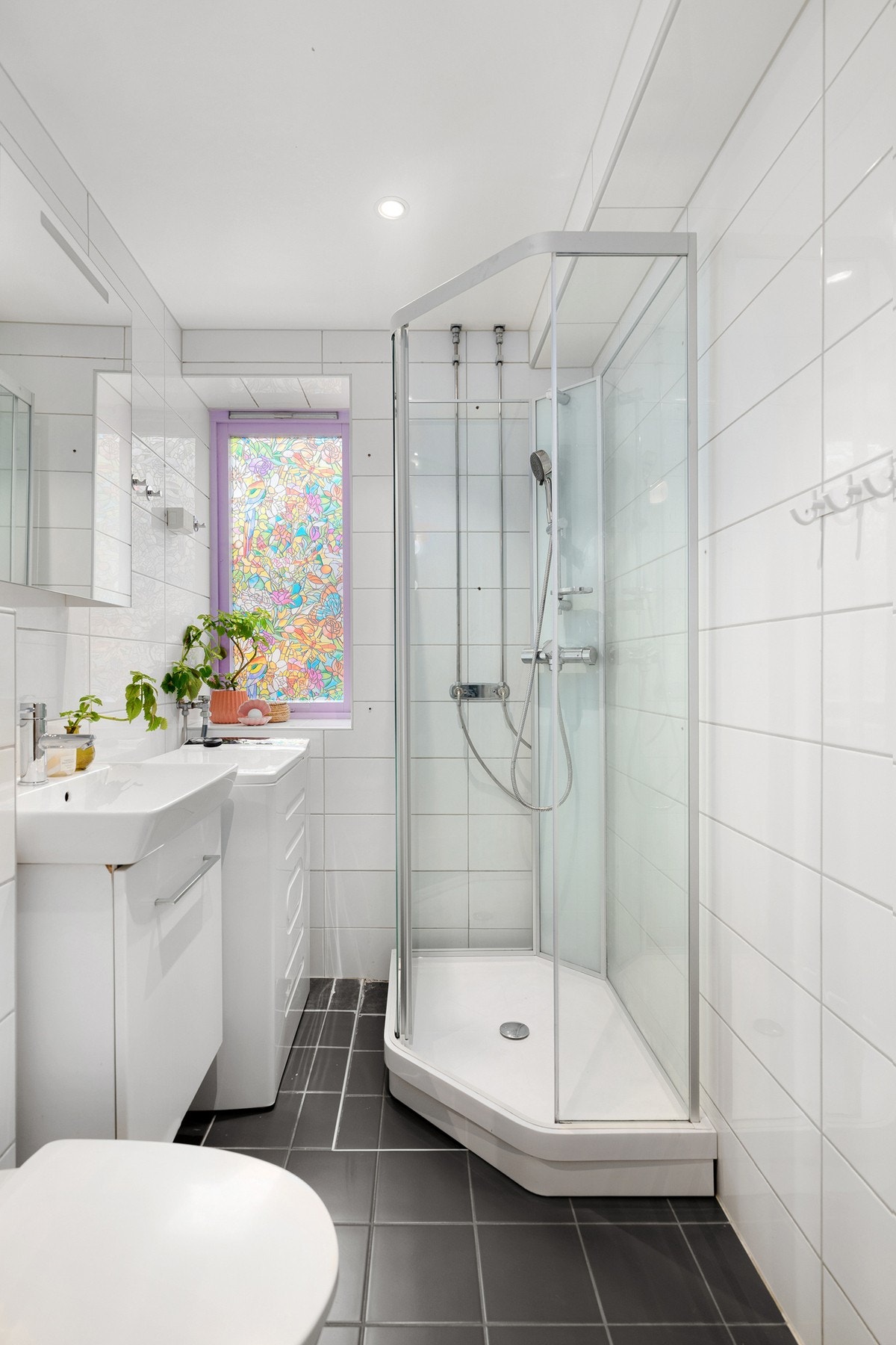 Leiligheten har et lyst og moderne flislagt baderom fra 2012. Baderommet har mørke fliser på gulv med gulvvarme, hvite fliser på veggene og downlights i himlingen. Galleribilde