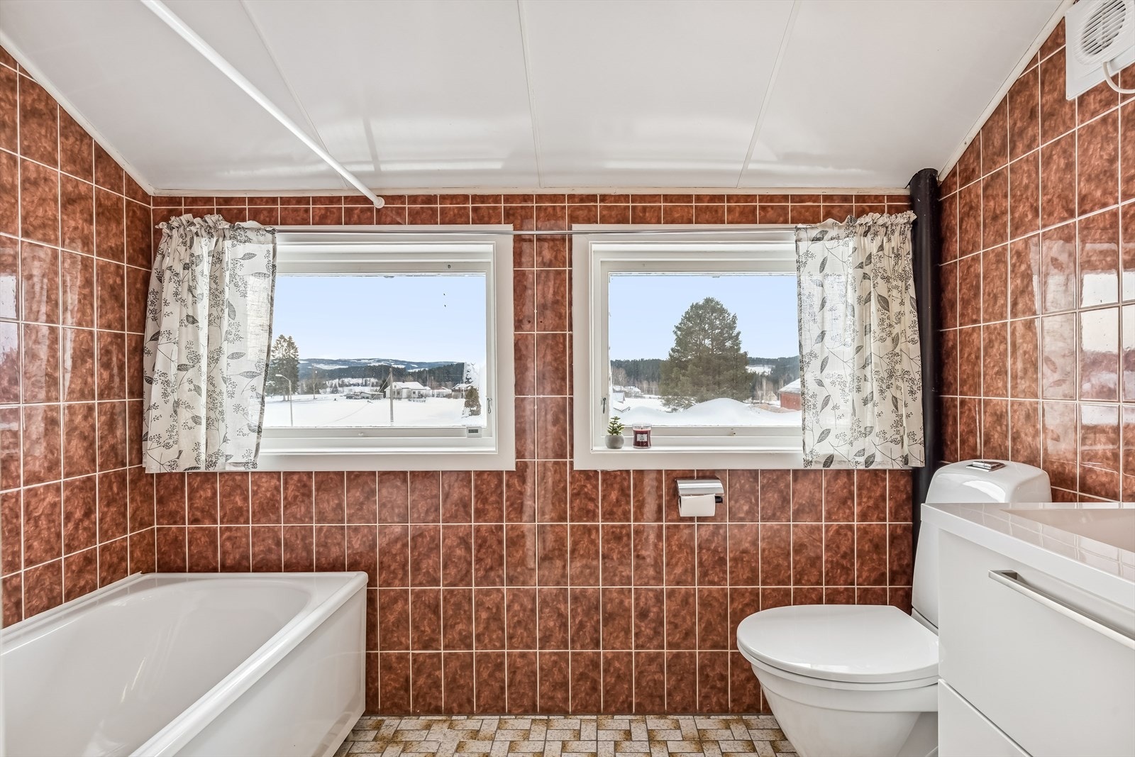 Badet i andre etasje er utstyrt med badekar, flislagt gulv med gulvvarme og flislagte vegger. Galleribilde