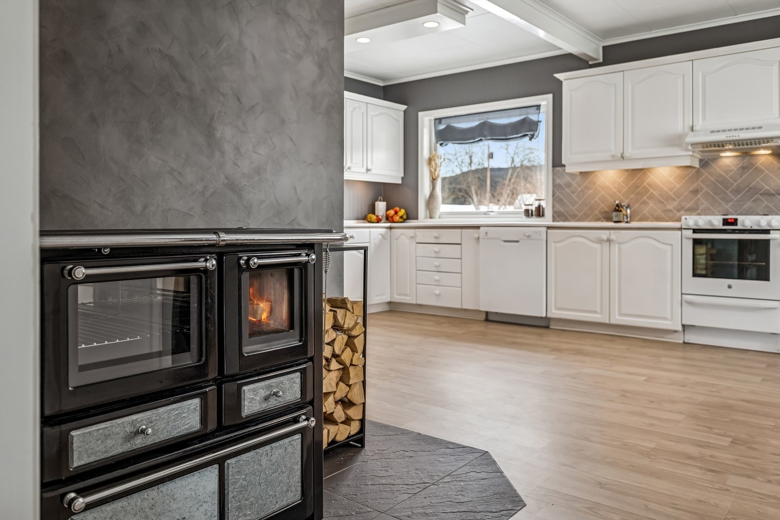 En sjarmerende vedfyrt komfyr fra 2023 gir både ekstra varme og en unik matlagningsmulighet. Galleribilde