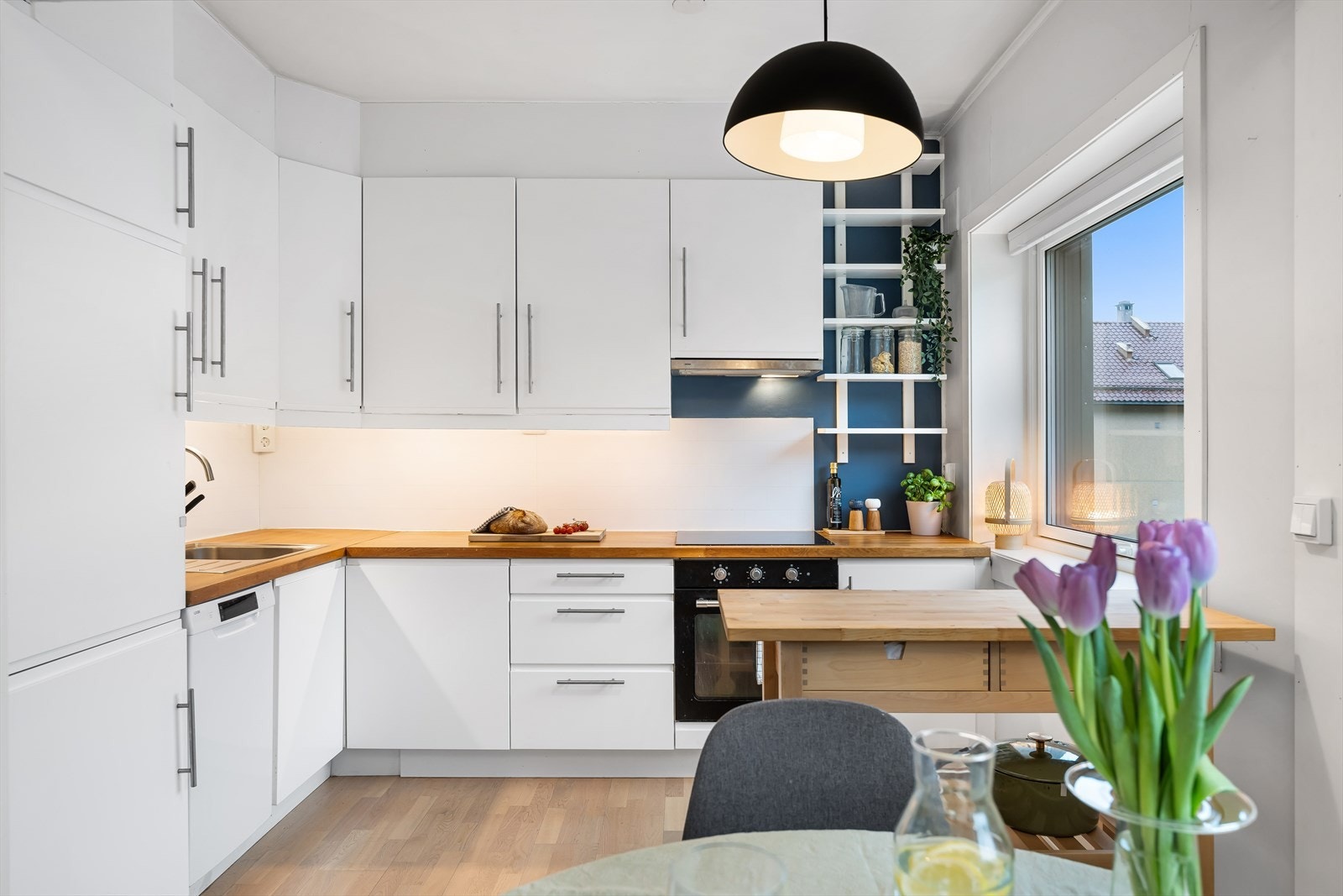 Flott kjøkkeninnredning med lyse slette fronter og heltré benkeplate med nedfelt vask. Galleribilde