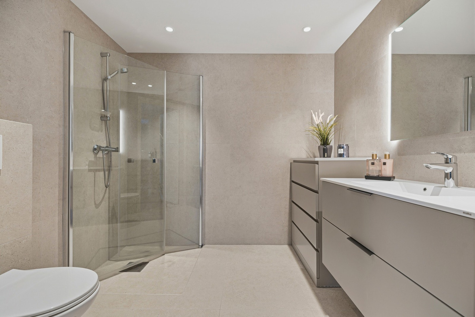 Lekkert bad med 60x60 fliser på gulv og vegger. Pene farger med matchende innredning med god skuffeplass Galleribilde