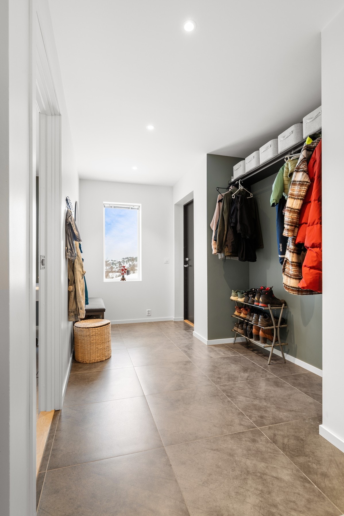 Flislagt entré med ryddig løsning for yttertøy og sko med hylle øverst Galleribilde