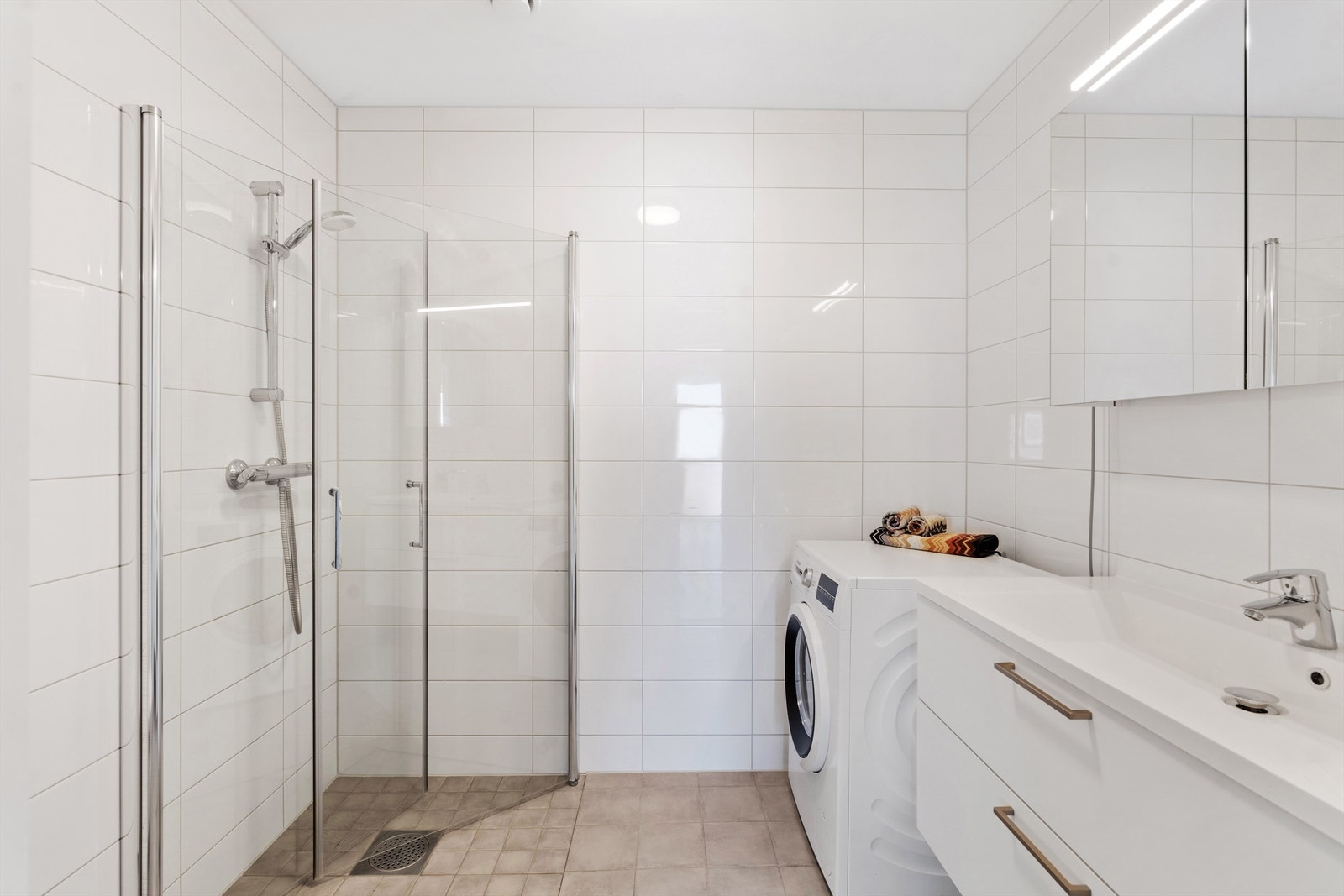 Helfliset baderom med dusj, opplegg for vaskemaskin og vannbåren varme i gulvet. Galleribilde