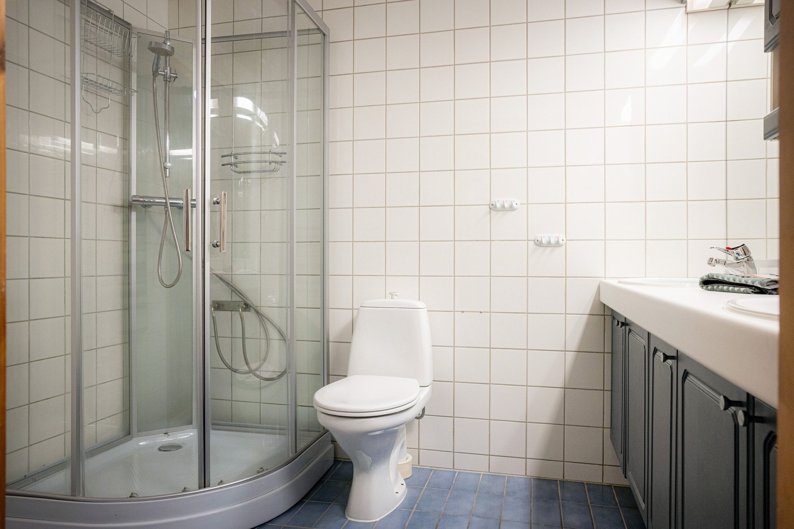 Flislagt baderom i u.etg med med gulvvarme. Innredningen er bestående av dobbel servant med underskap, speil med overlys, veggskap, gulvmontert klosett og dusjkabinett. Galleribilde