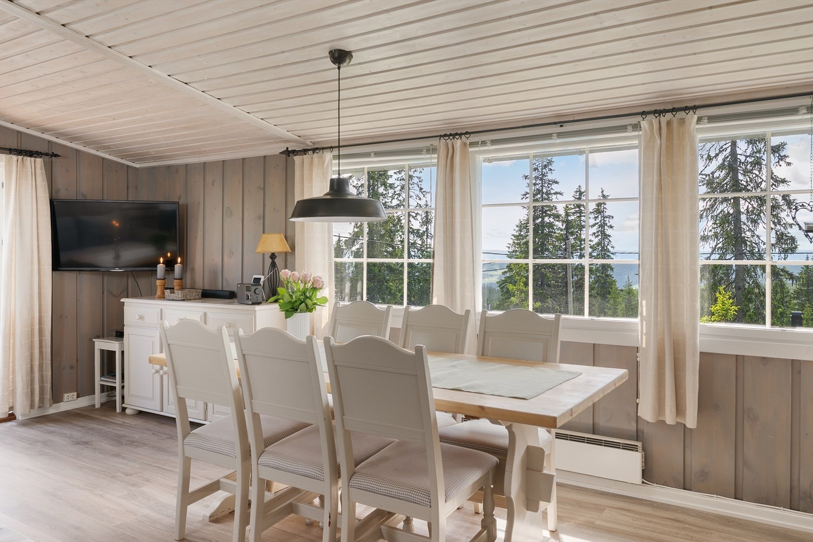 Flint lys inn over spisebordet. Hyggelig å kunne samles rundt langbordet for felles måltider. Galleribilde