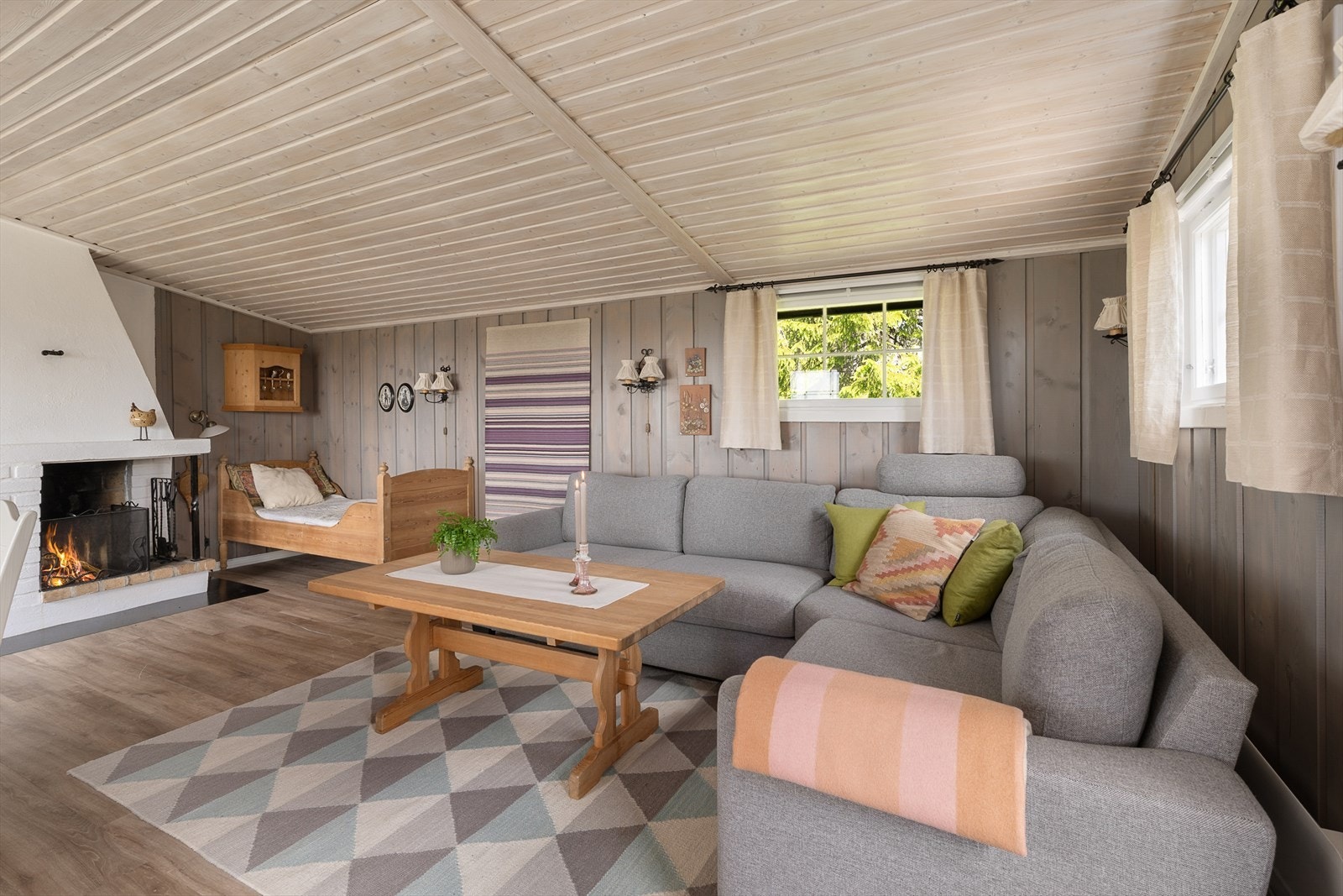 Det er plass til en god sofa foran peisen i hytta. Galleribilde